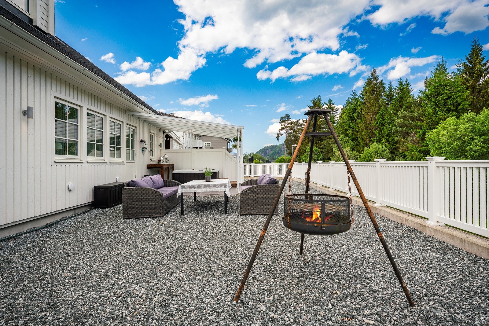 Tomten er opparbeidet med gruset innkjørsel/parkering, gruset areal, murer og terrassedekk. Galleribilde