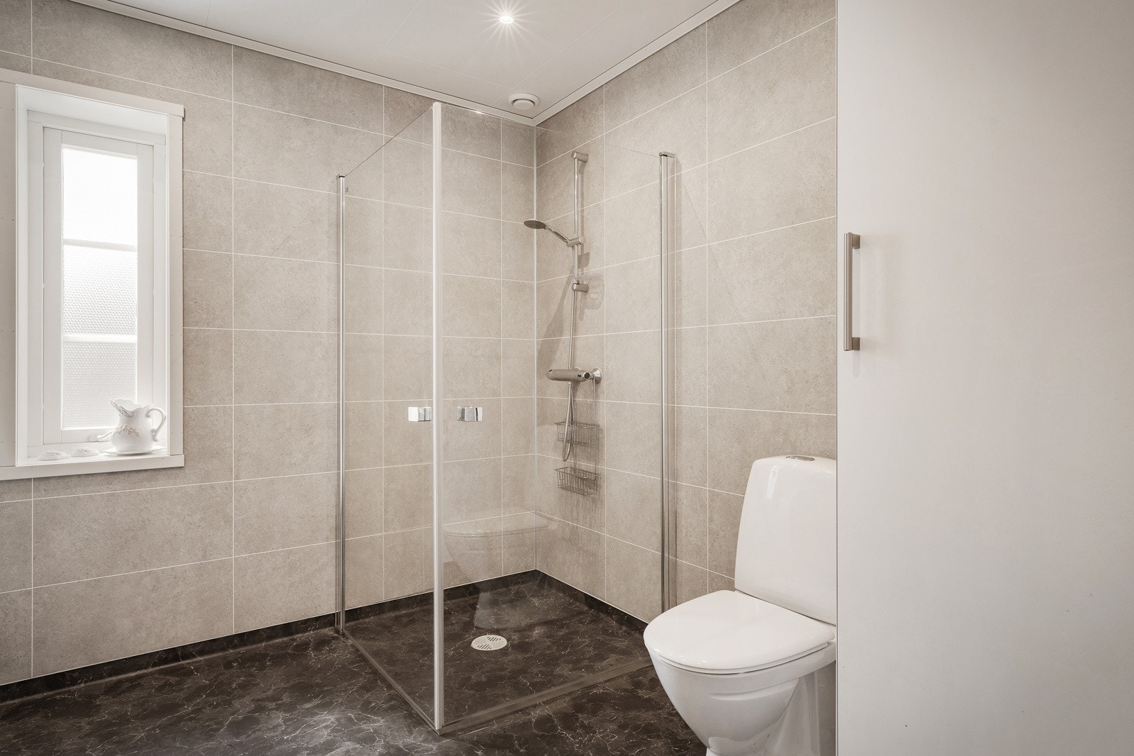 Ïnnredningen består av toalett, dusj med glass foldedør, dobbel servant, speil og belysning. Galleribilde