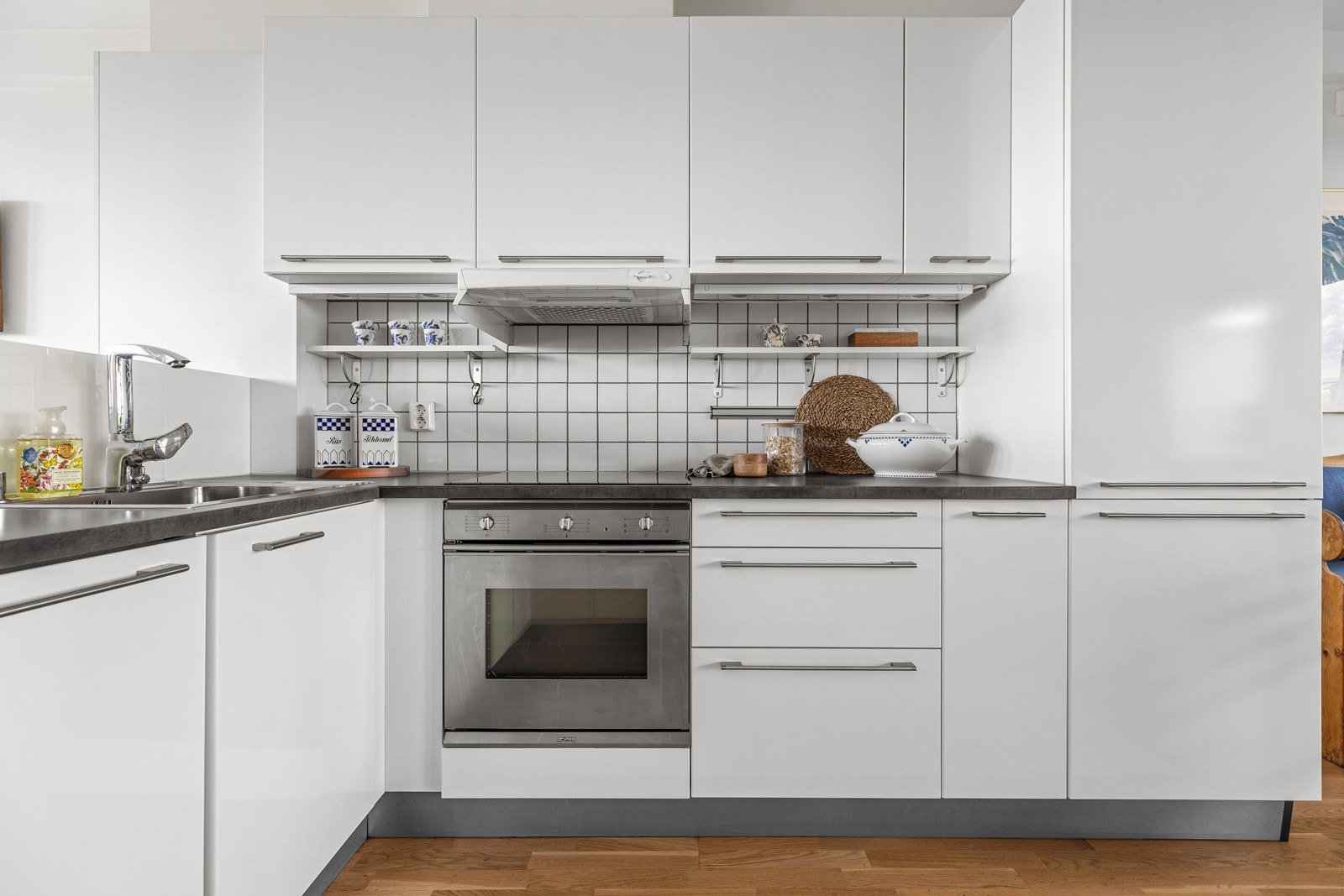 Innredningen består av fronter i hvit høyglans med stålhåndttak, laminat benkeplate samt integrerte hvitevarer fra Bosch, Miele og Smeg Galleribilde