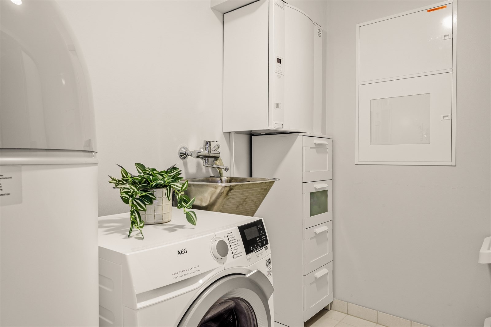 Praktisk vaskerom med rør i rør skap, bereder, sikringsskap og aggregat til balansert ventilasjon. Fine lagringsmuligheter har du også. Galleribilde