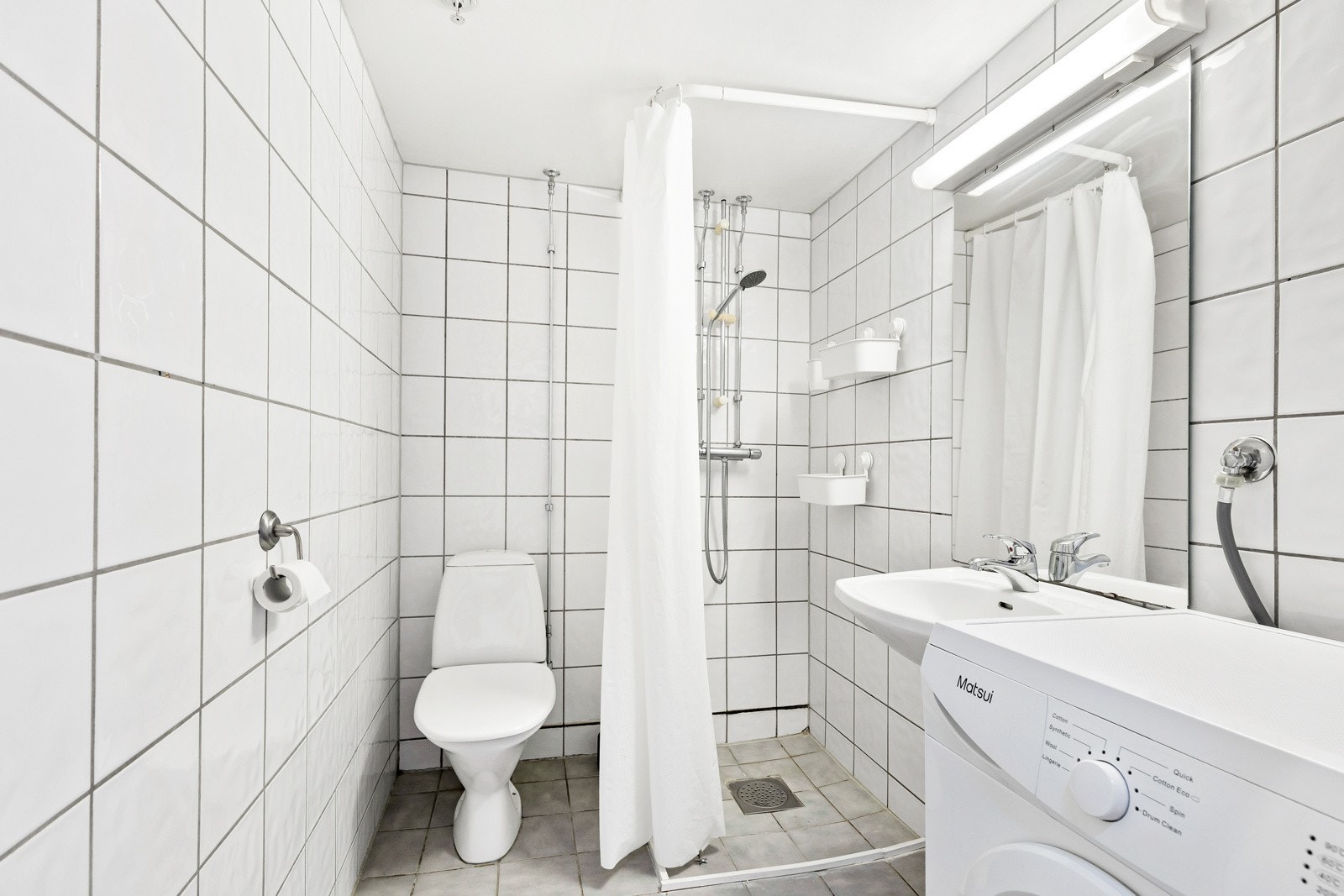 Badet er utstyrt med servant, toalett, dusjhjørne og opplegg for vaskemaskin. Galleribilde