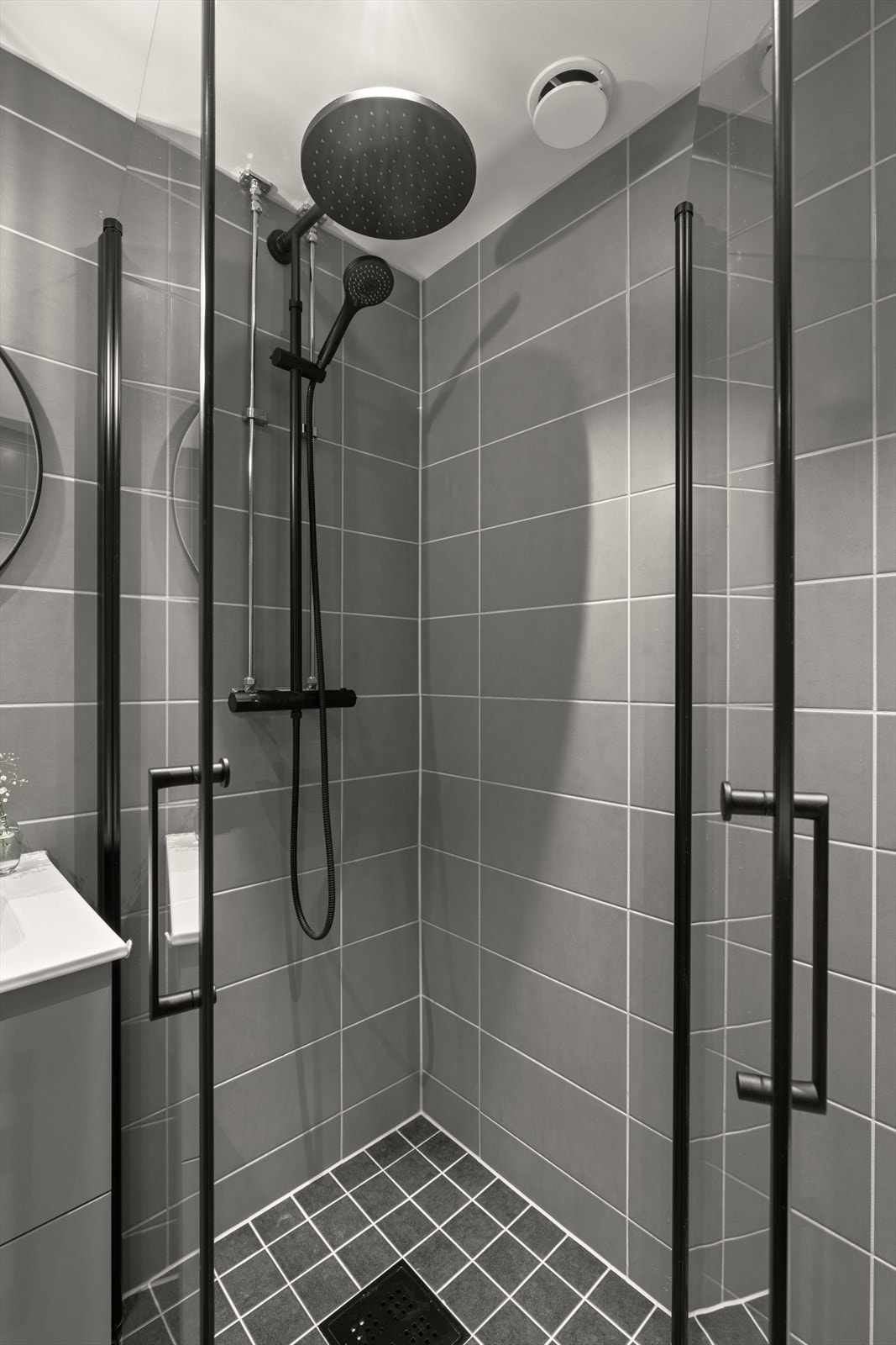 Badet består av dusjhjørne med innfellbare dusjdører, servant med oppbevaring, vegghengt toalett og opplegg for vaskemaskin Galleribilde
