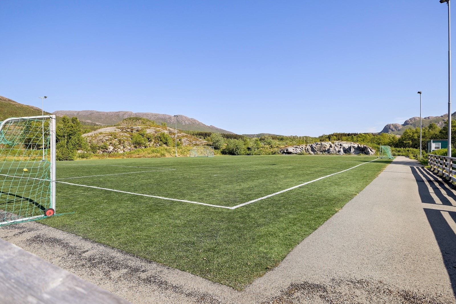 Kunsgressbane ved skolen og barnehagen. Etablert lekeapparater for de minste, mens far leker Ronaldo ... Galleribilde