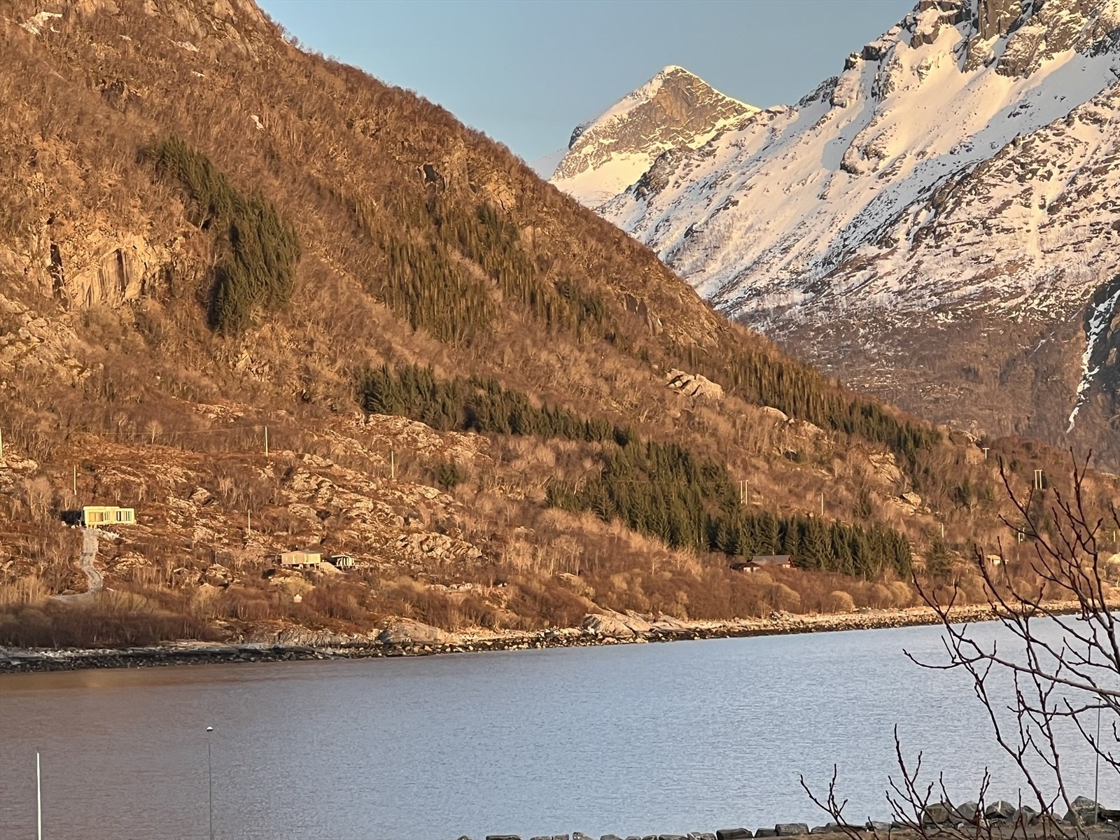 Bildet tatt fra Naustneshågen mot tomten og områdene rundt en vårdag i 2024. Lang solgang med kveldsol. Galleribilde