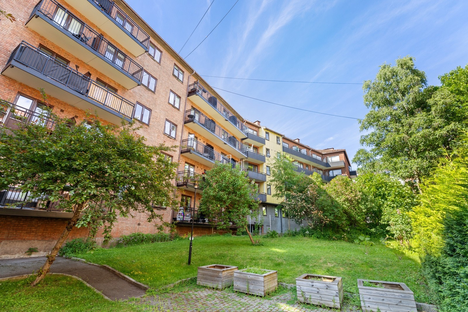 Bakgården til Gjøvikgata 7 er en velholdt og fredelig grønn lunge midt i byen, designet for å skape et hyggelig fellesskap. Galleribilde
