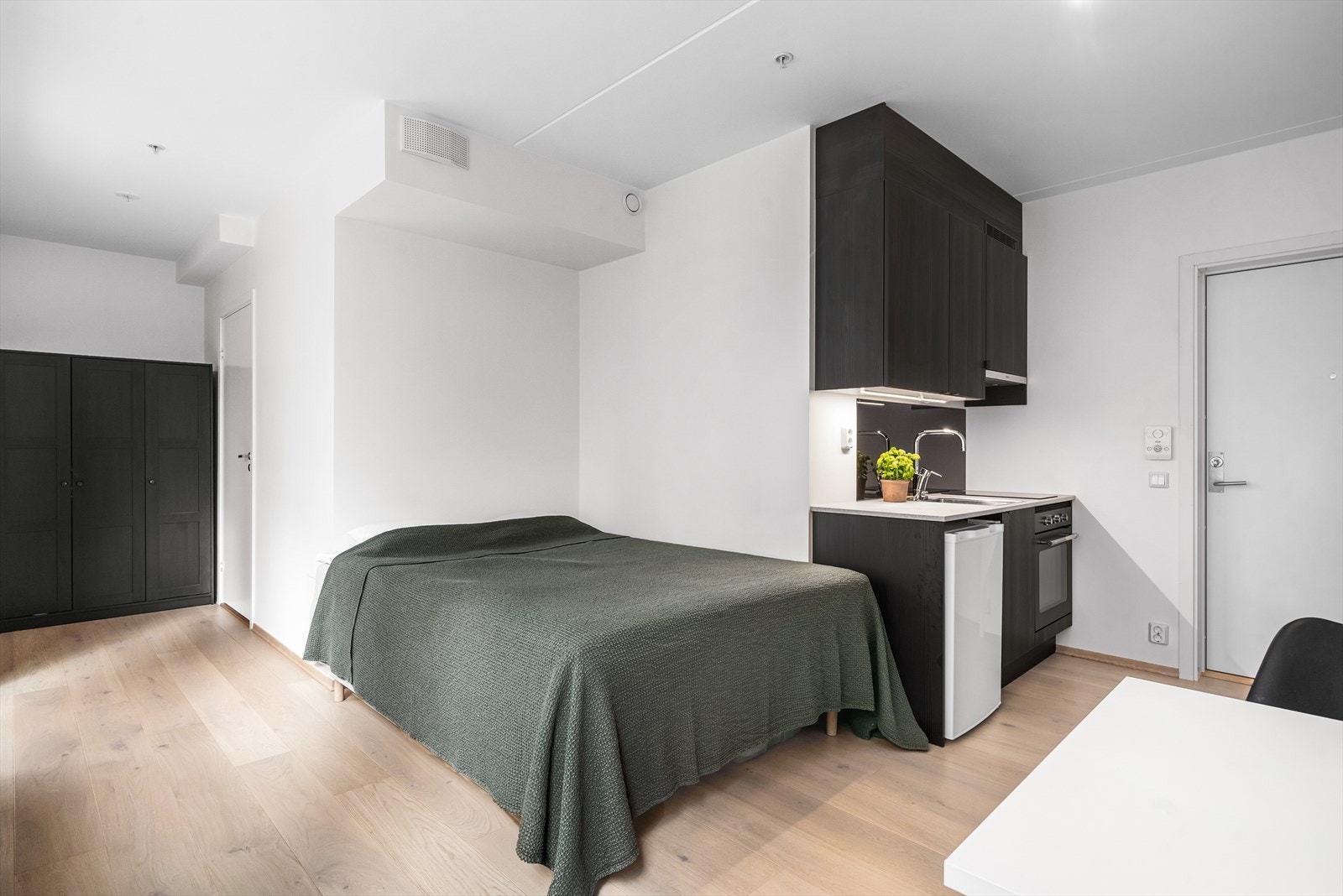 Kjøkken i åpen løsning med stue. Stilren og moderne kjøkkeninnredning fra HTH med laminat benkeplate og medfølgende hvitevarer. Galleribilde