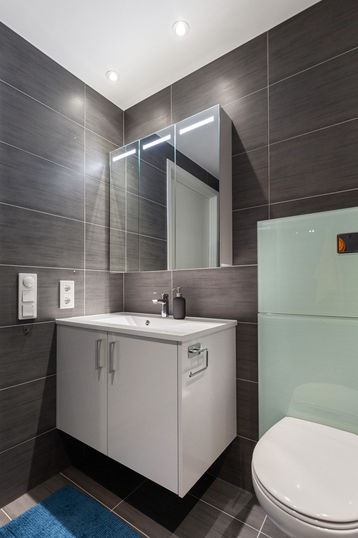 Badet er utstyrt med baderomsinnredning, toalett, dusjplass og opplegg for vaskemaskin Galleribilde