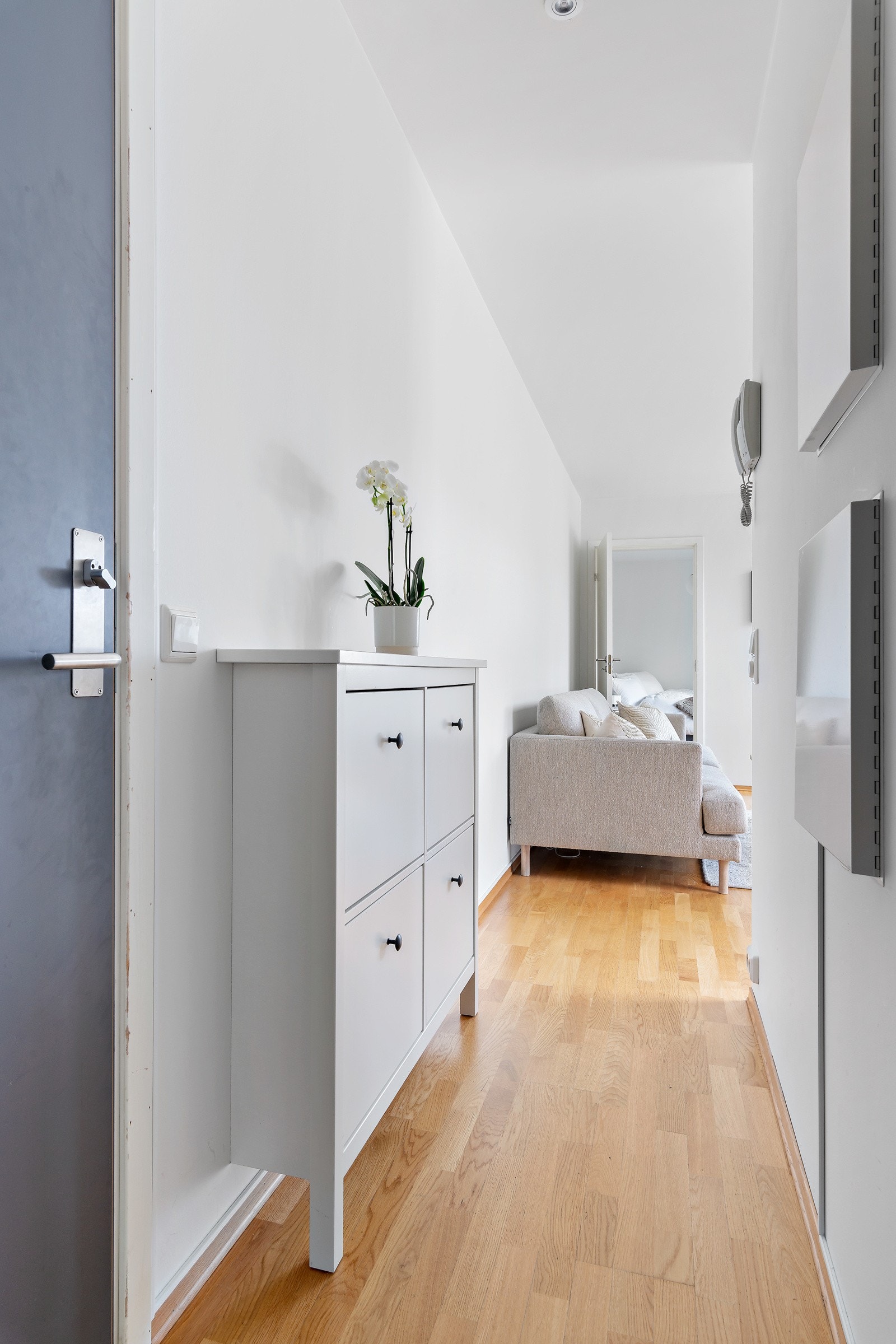 Velkommen inn. Det er montert skoskap langs veggen og montert skyvedørsgarderobe med speil for oppbevaring. Galleribilde