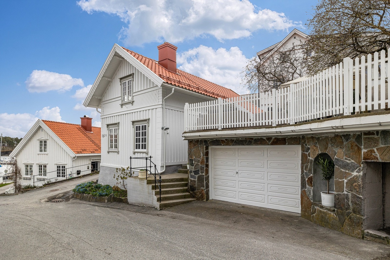 Garasjen har terrasse over. Fin mur med naturstein. Galleribilde
