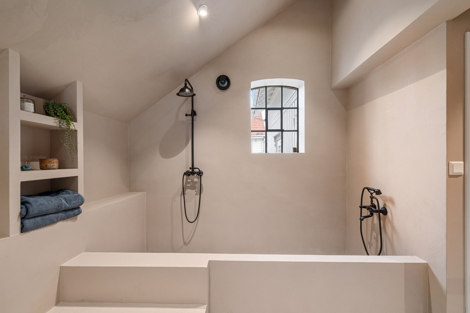 Dusjsonen er original, men praktisk. En stor regndusj og hånddusj plassert på hver sin side innenfor den rektangulære sonen. Galleribilde