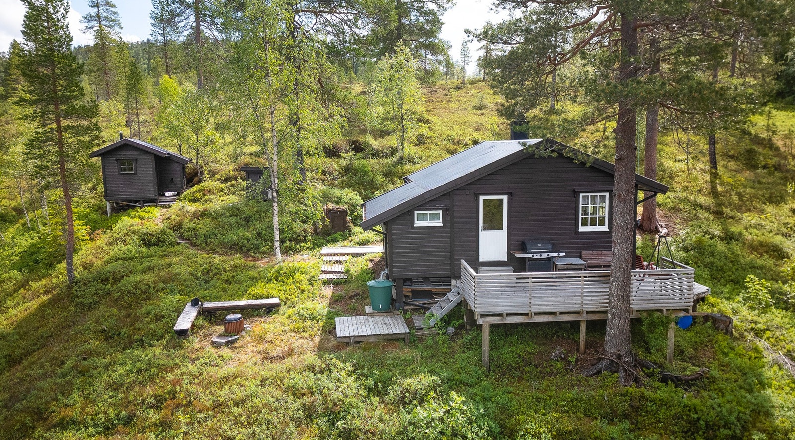 På tomten finner du også et lite uthus med bod og utedo Galleribilde