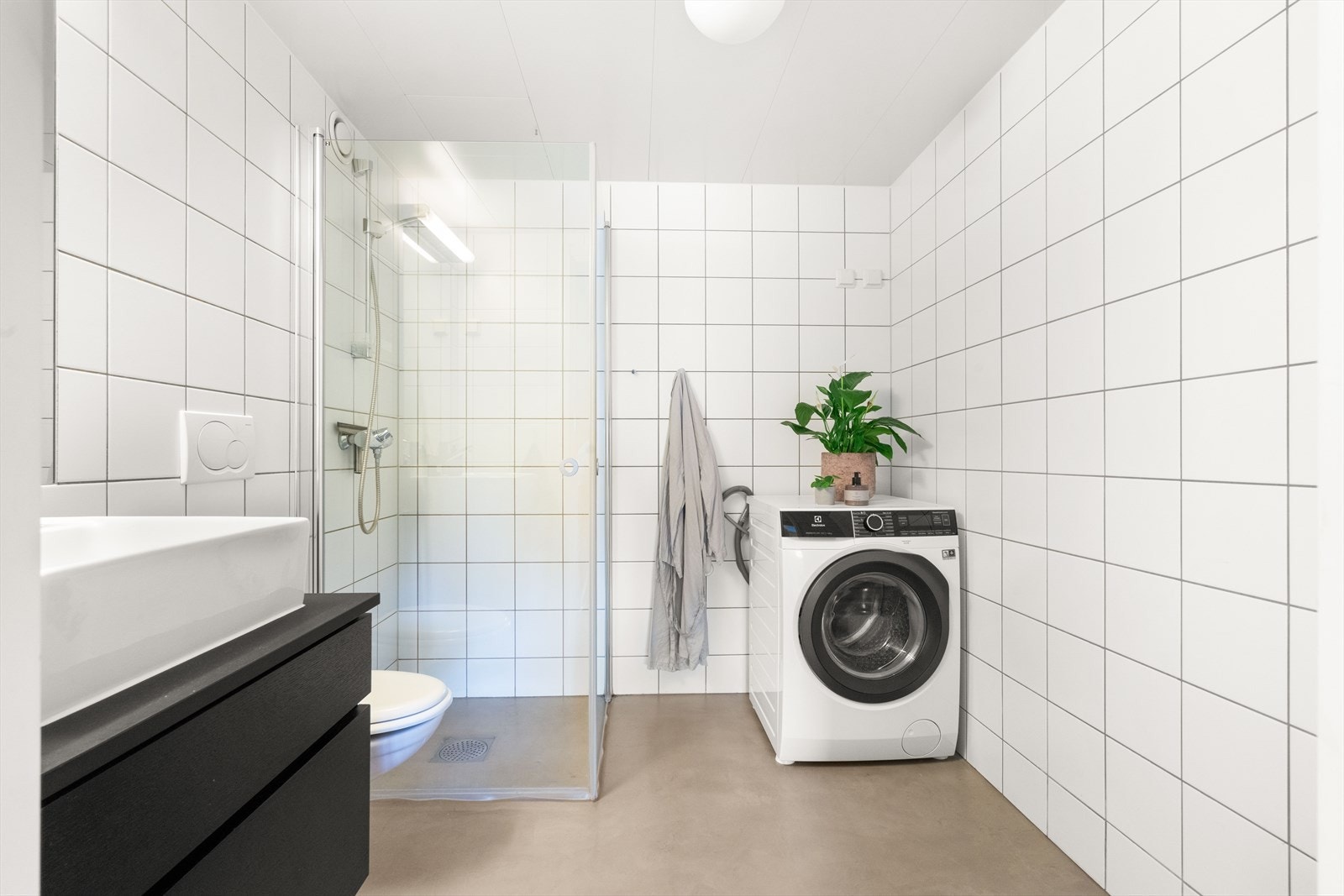 Badet er moderne og stilfullt, med flislagte vegger og gulv påført mikrosement som gir et elegant og holdbart uttrykk. Galleribilde