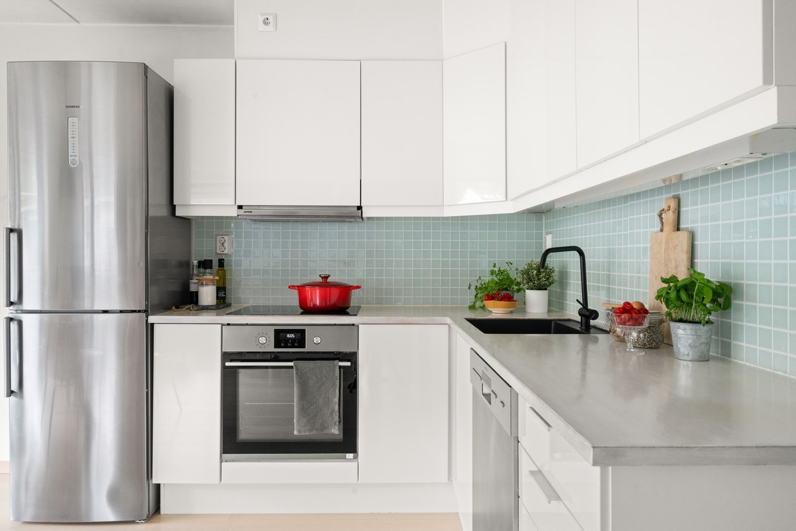 Lekkert kjøkken fra Sigdal med lyse, slette fronter utstyrt med trykk-åpningsfunksjon, benkeplate i treverk, samt nedfelt oppvaskkum med 1-greps blandebatteri. Galleribilde