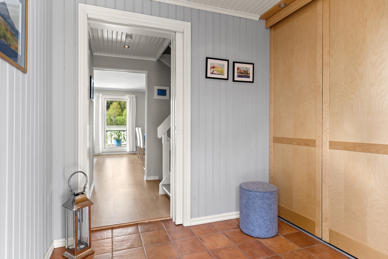 Innbydende entré med malt panel og flislagt gulv med varmekabler under. Galleribilde