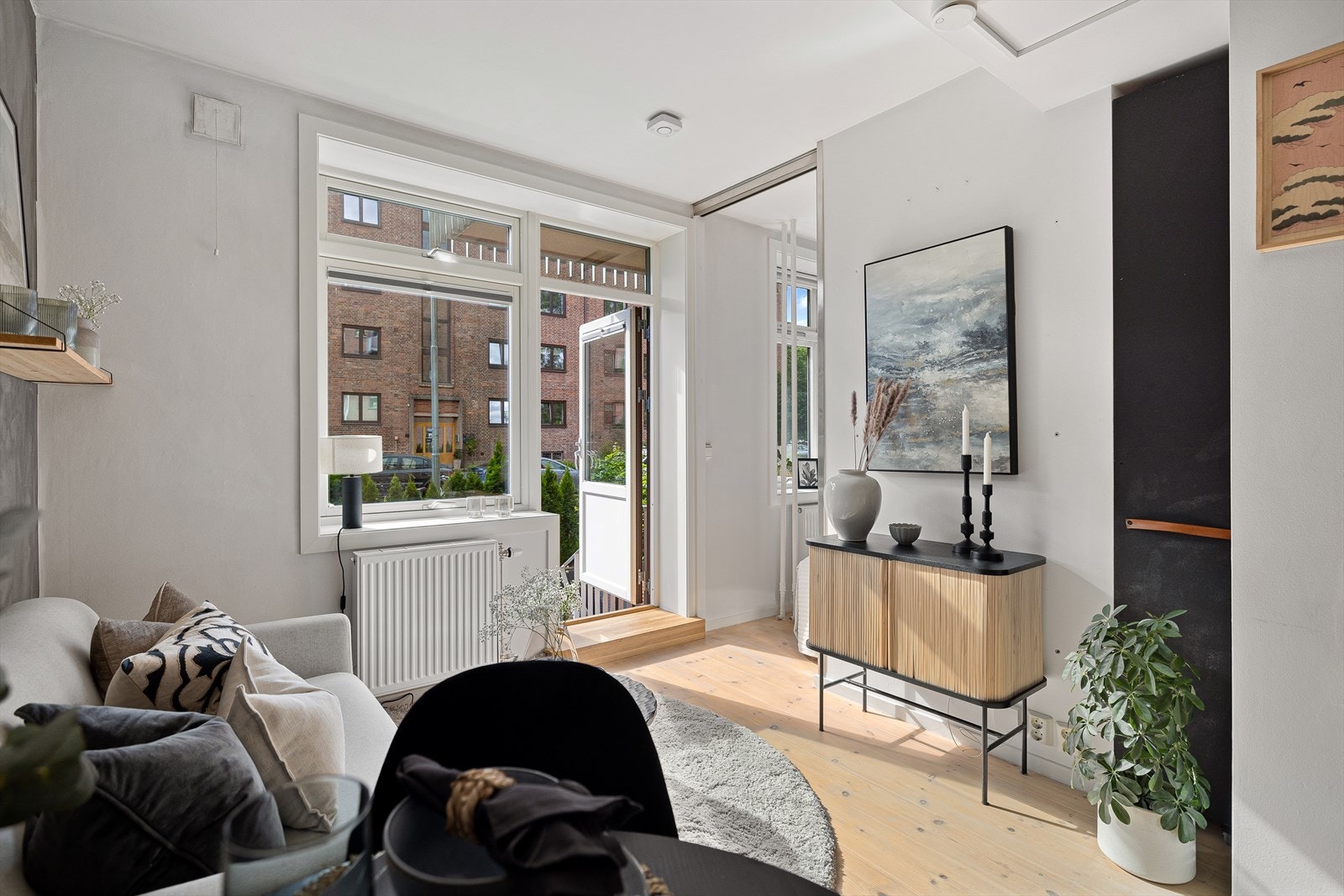 Det er plass til sofa og et lite spisebord i tilknytning til kjøkkenet. Til høyre i bilde er det en smart oppbevaringsløsning til for eksempel dyner, puter og sengetøy Galleribilde