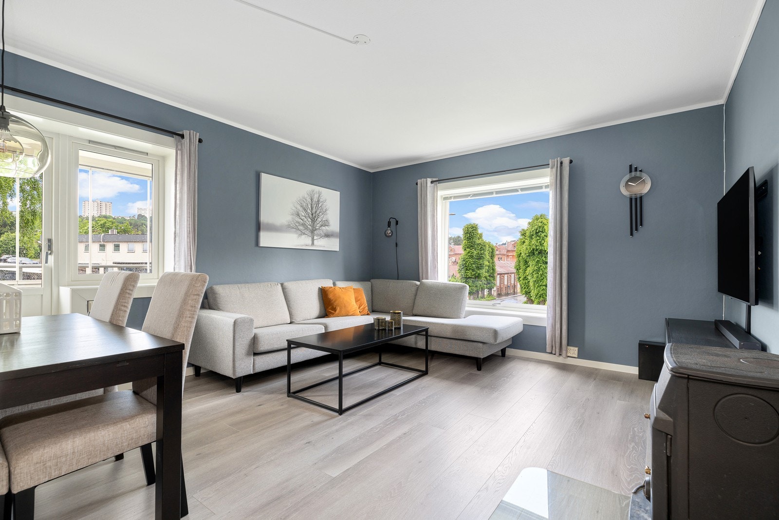 Lys og romslig stue med laminat på gulv og malt tapet på vegg i lun farge Galleribilde