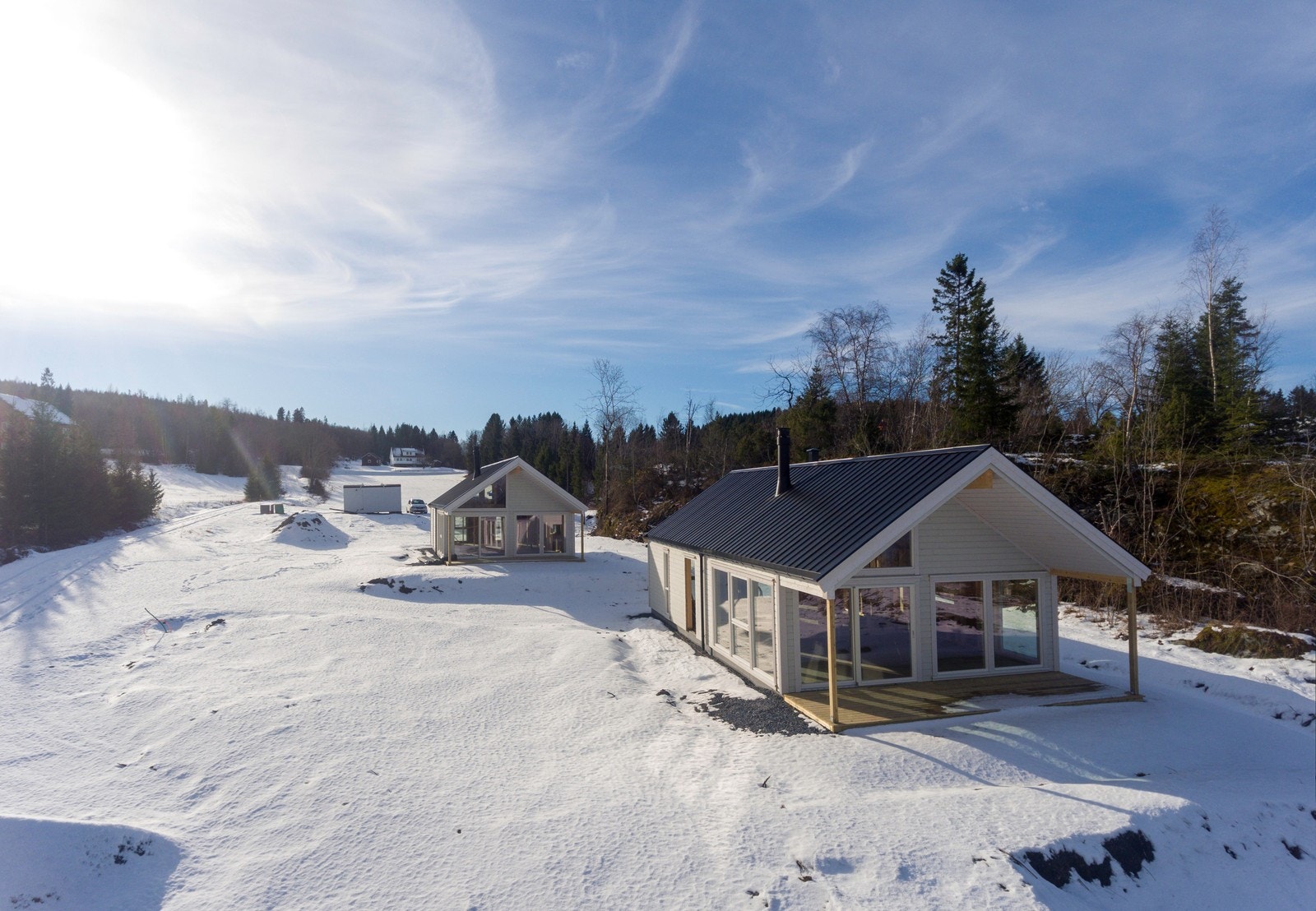Hytta har store glassflater i front og åpen himling i stue og kjøkken Galleribilde