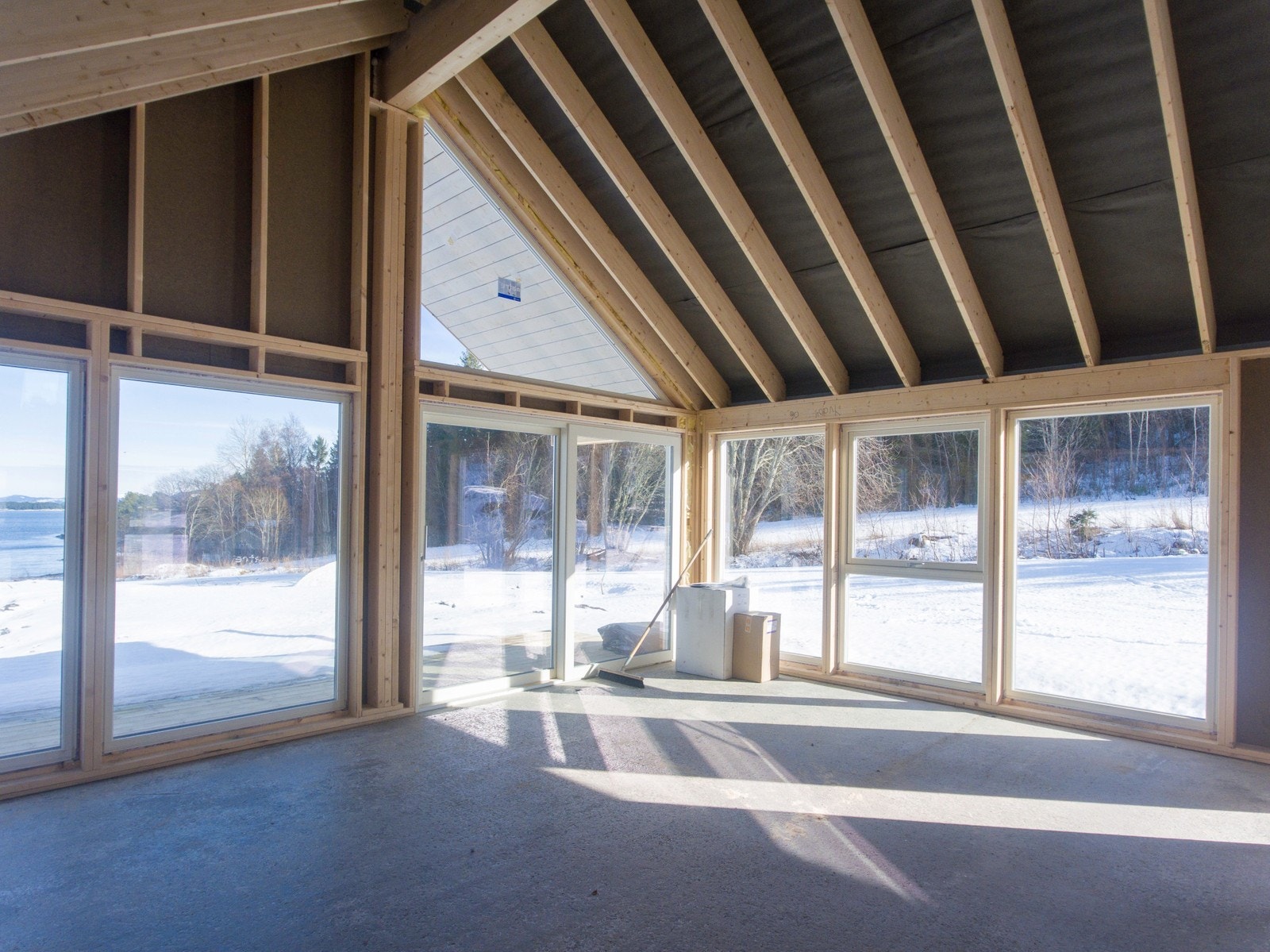 Hytta har store glassflater i front og åpen himling i stue og kjøkken Galleribilde