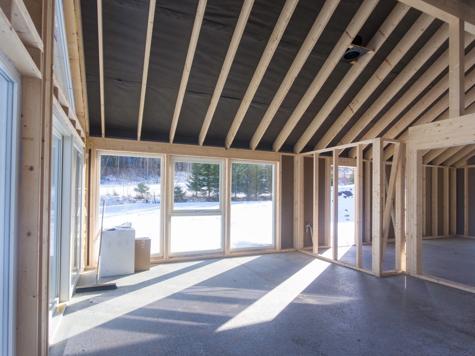 Hytta har store glassflater i front og åpen himling i stue og kjøkken Galleribilde