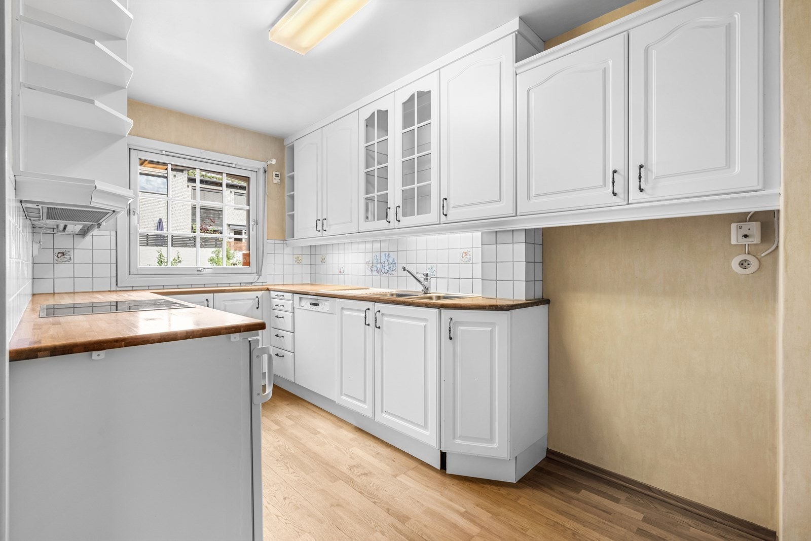 Innredningen er pent utført med hvite, profilerte fronter med heltre benkeplate og nedfelt kum i rustfritt stål. Galleribilde