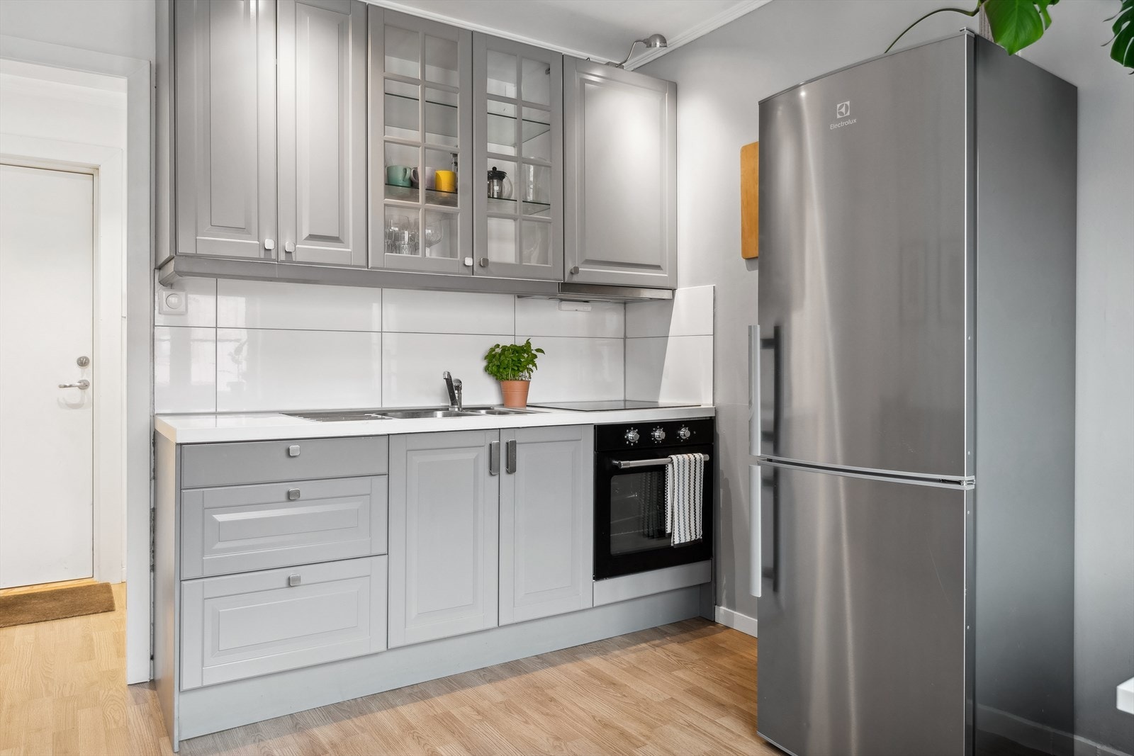 Stilig kjøkkeninnredning med ett speils lakkerte skapfronter og laminat benkeplate Galleribilde