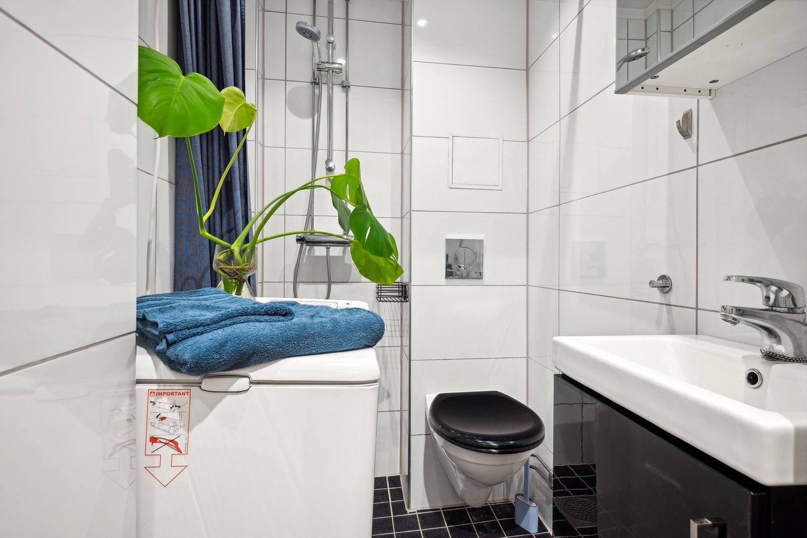 Badet er pent flislagt med varmekabler i gulv og opplegg for vaskemaskin - vaskemaskin medfølger salg Galleribilde