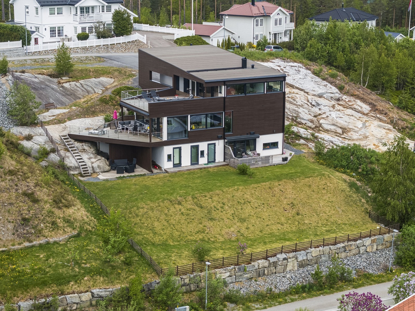 Boligen er bygd fint inn i terrenget og har store, sydvendte utsiktsterrasser utenfor alle etasjene. Galleribilde