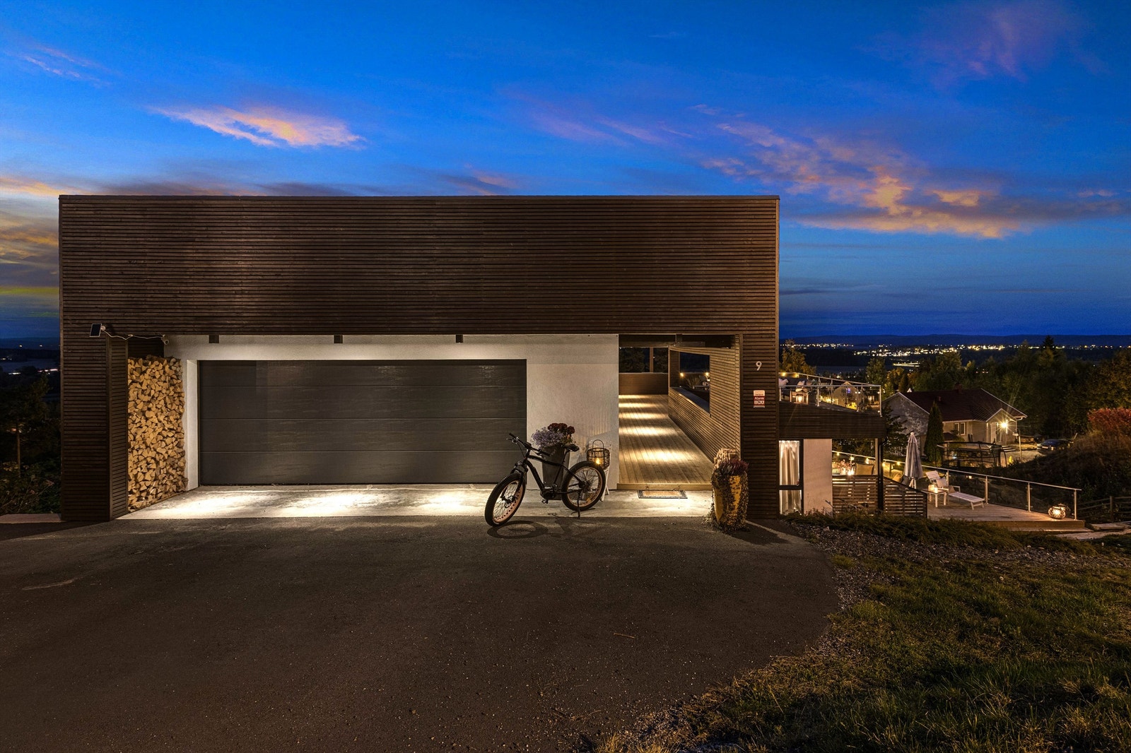 Asfaltert gårdsplass utenfor toppetasjen med integrert dobbeltgarasje med elbillader. Galleribilde