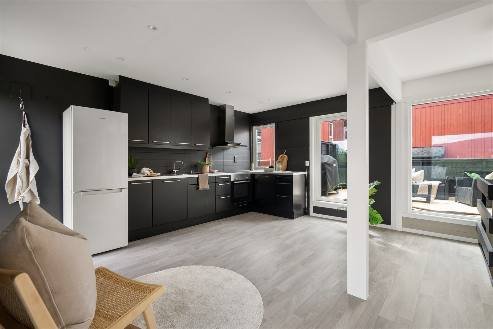 Flott kjøkken med mørke slette fronter og lys benkeplate i laminat. Galleribilde