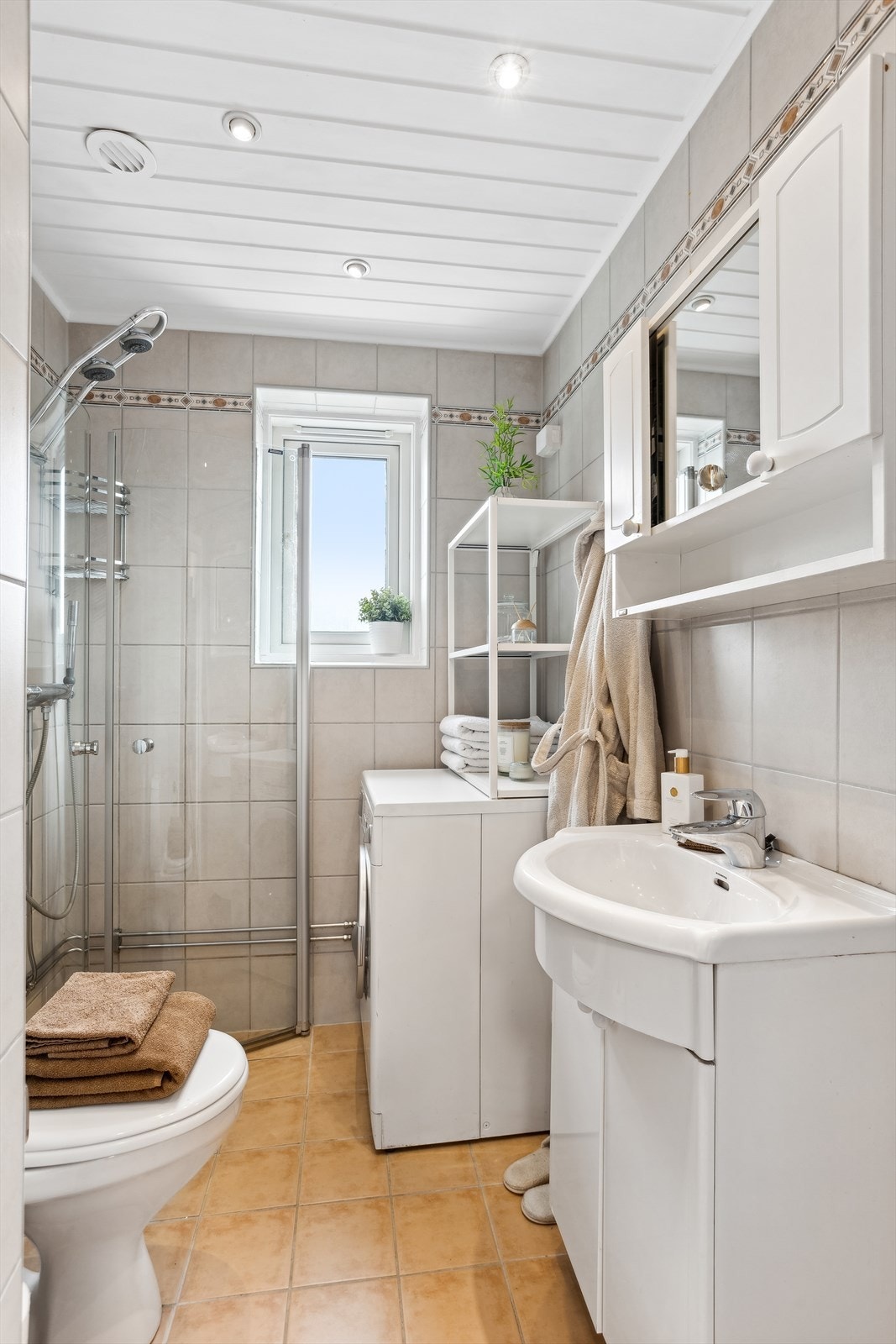 Badet er fra 2005, det er flislagte overflater og gulvvarme. Innredningen består av nedfelt servant med tilhørende speilskap, toalett, dusjhjørne med praktiske innfellbare glassdører samt opplegg for vaskemaskin. Galleribilde