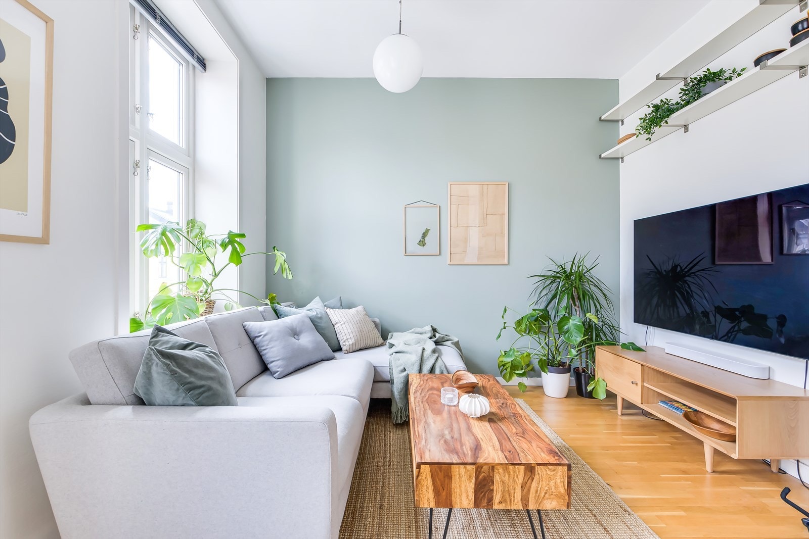 Leilighetens stue er lys og innbydende med flotte flaggvinduer og en imponerende takhøyde på 2,7 meter som skaper en luftig atmosfære. Galleribilde