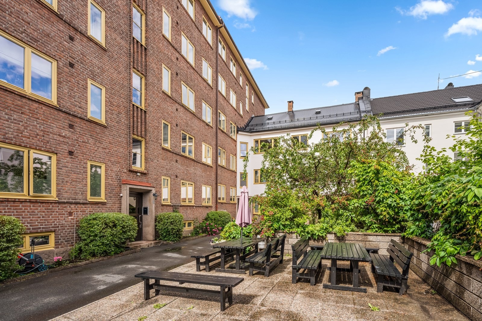 Pent opparbeidet og hyggelig bakgård med beplantning og sittegrupper. Galleribilde
