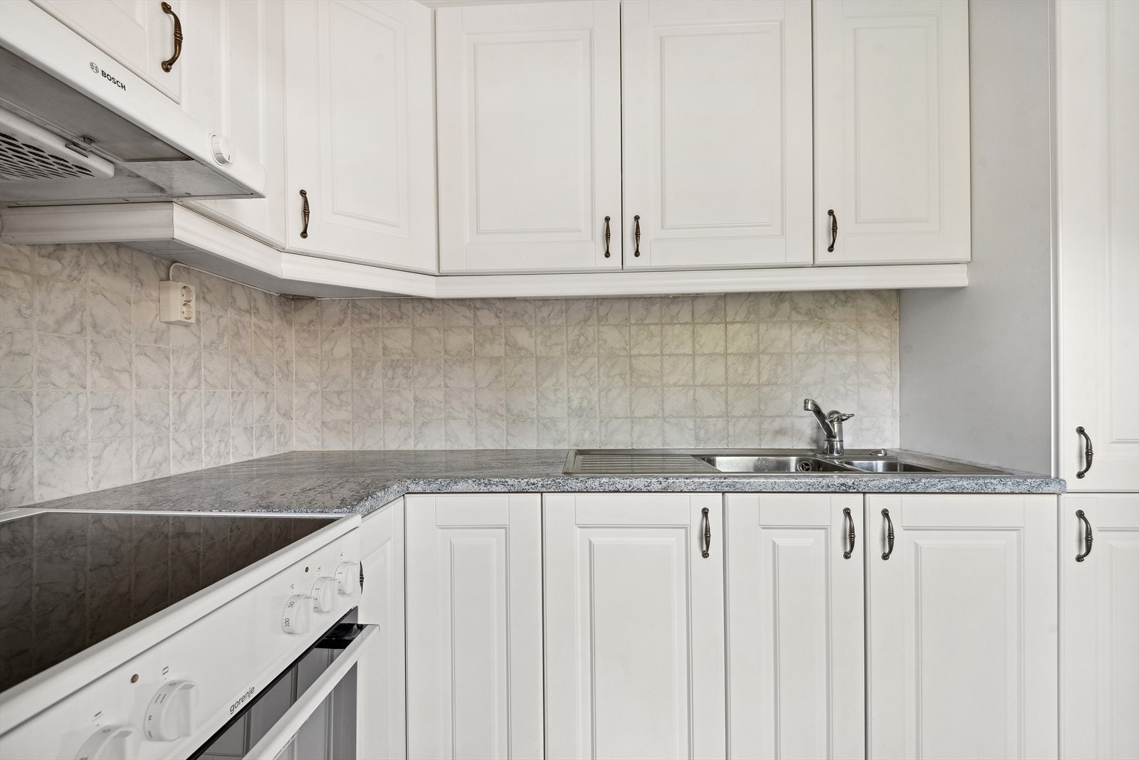 Innredningen består av over-, under- og høyskap i laminerte skrog med lyse, profilerte fronter. Laminert benkeplate med dobbel oppvaskkum i rustfritt stål. Galleribilde