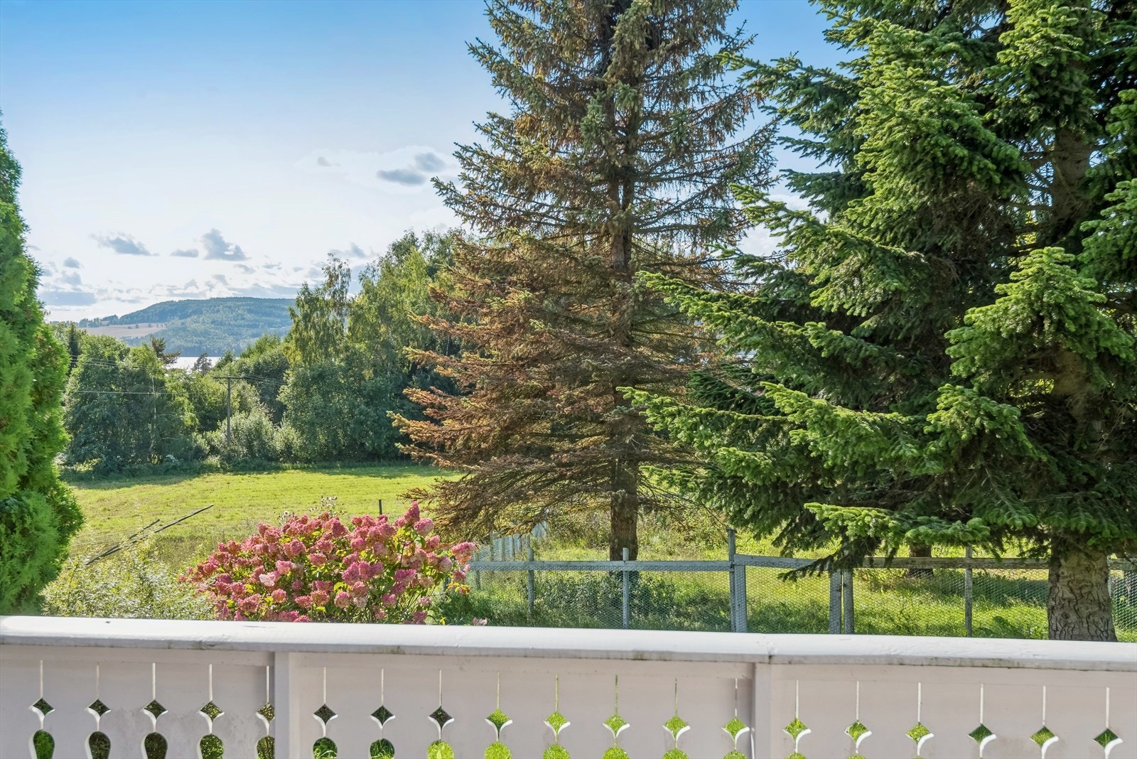 Det er fint utsyn over tomta, områdene rundt og til og med et lite glimt av Mjøsa. Galleribilde