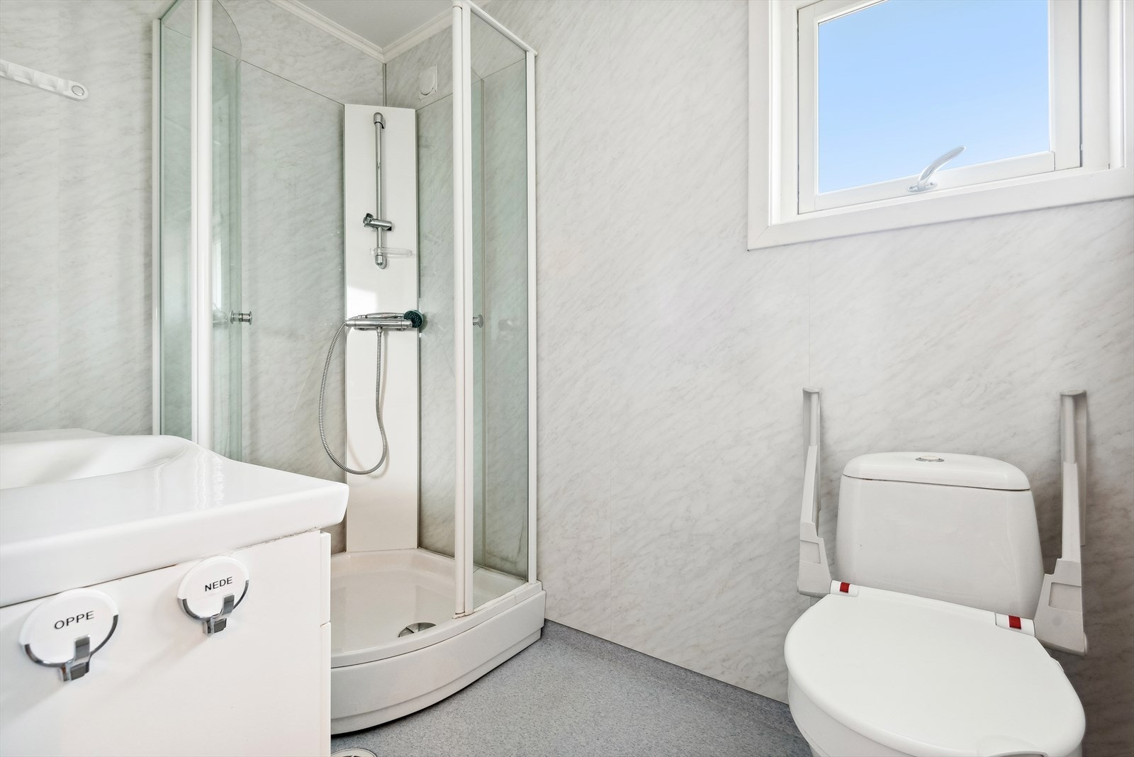 Badet har belegg på gulvet og våtromsplater på veggene. Det er elektriske varmekabler i gulvet. Galleribilde