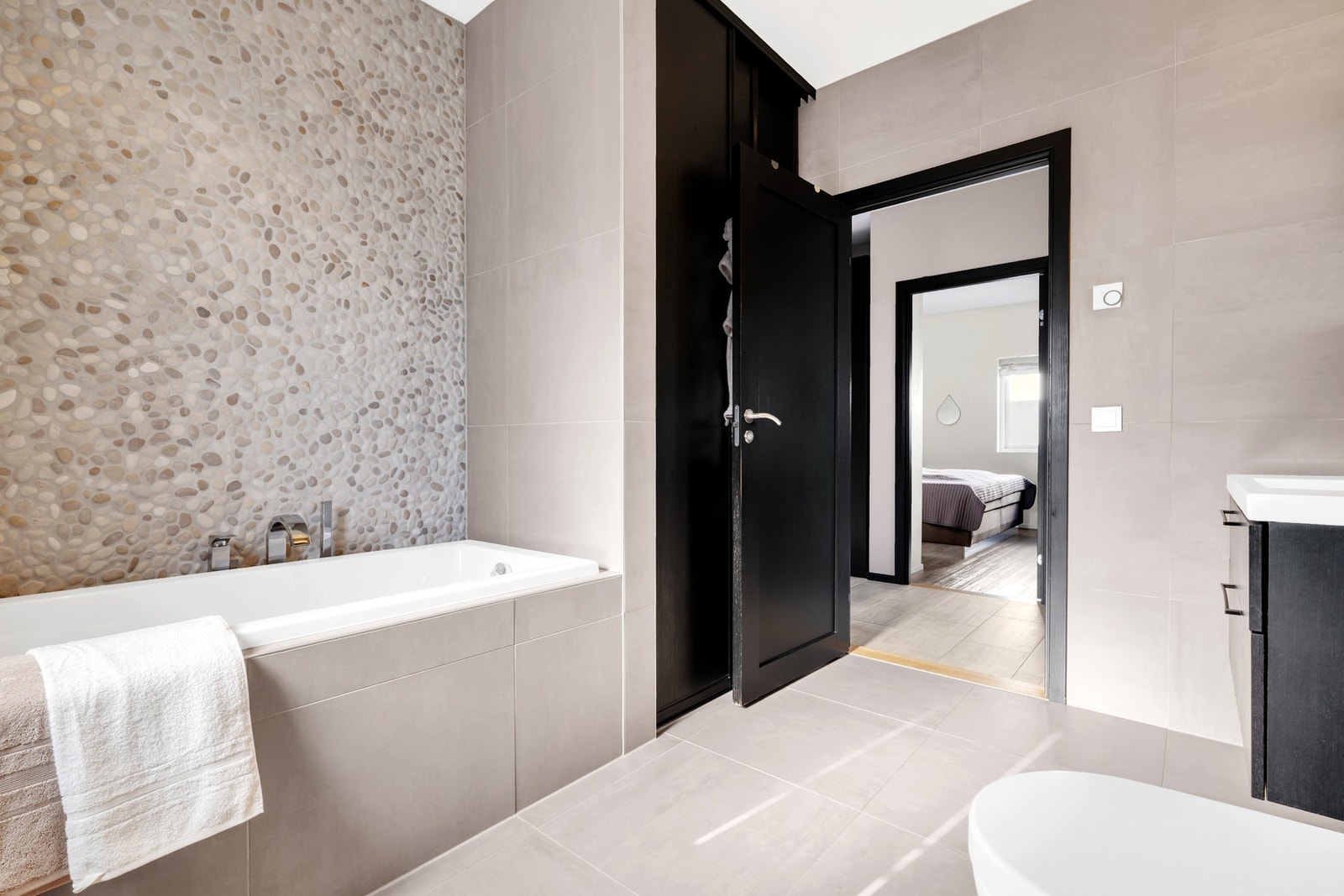 Her er det både dusjhjørne og badekar, samt opplegg for vaskemaskin og tørketrommel bak skyvedør. Galleribilde