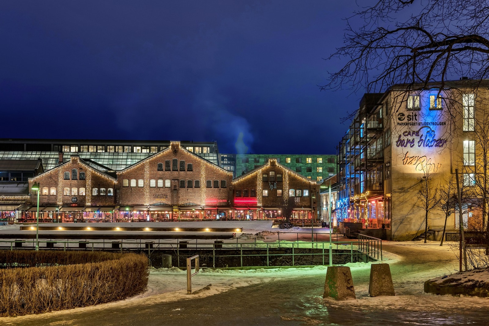 Elegant industriell mursteinsbygning ved vannet med ca. 50 forskjellige butikker og kafeer samt et spa. Galleribilde