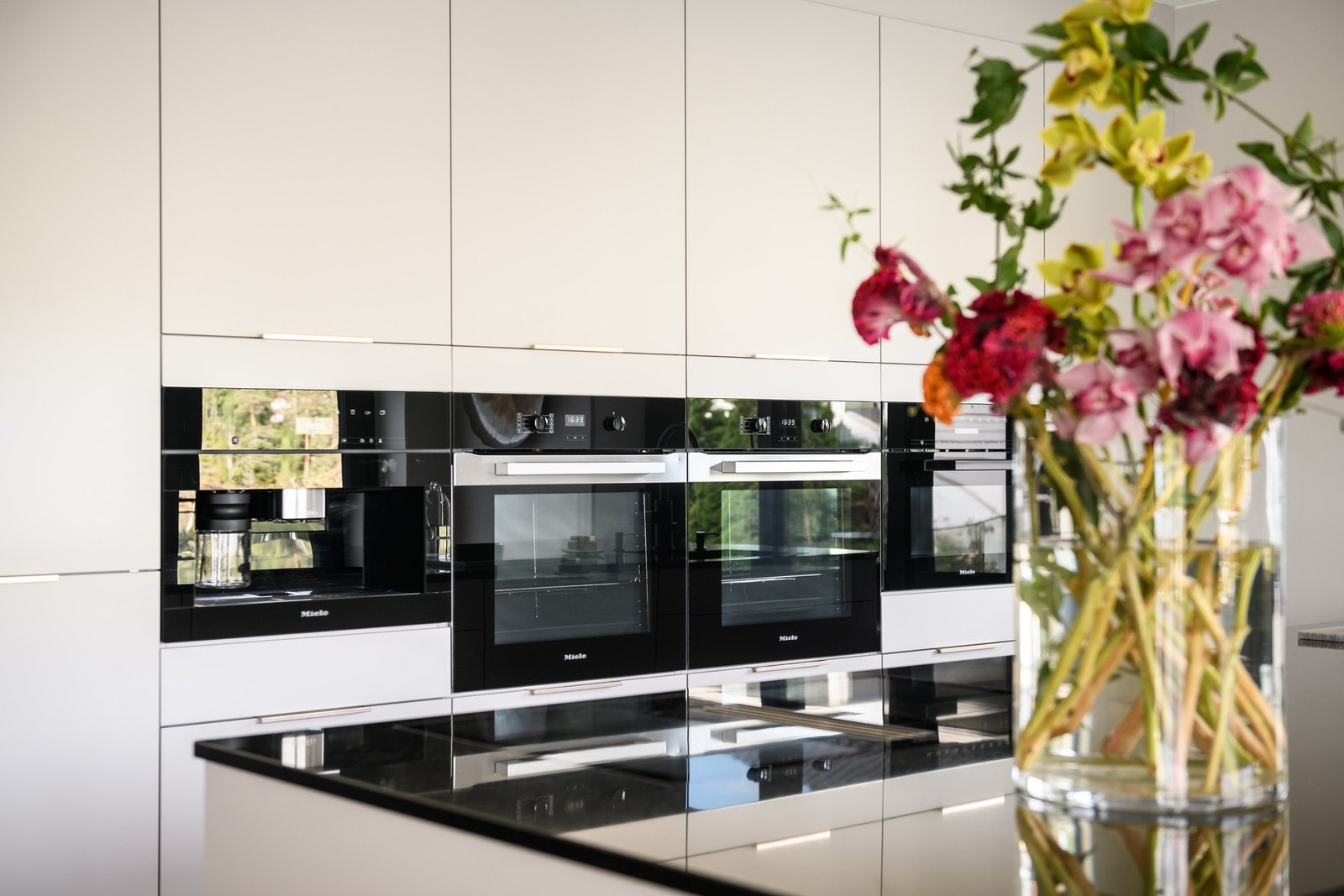 Gode løsninger og integrerte hvitevarer med topp kvalitet fra Miele. Benkeplate av sort stein. Galleribilde