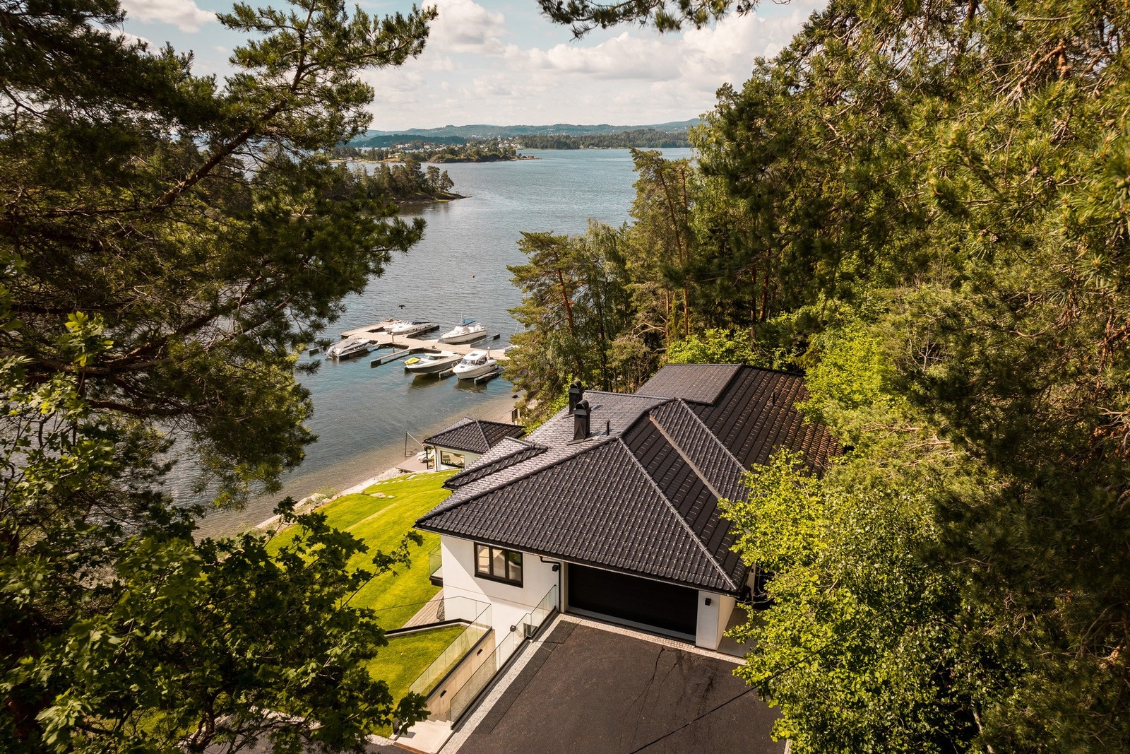 Nyasfaltert og varmekabler i innkjørselen. Det er montert elektrisk port med fjernkontroll i bakken ned til huset. Det er montert sort metallgjerde med høyde 1200 mm mot nabo. Galleribilde