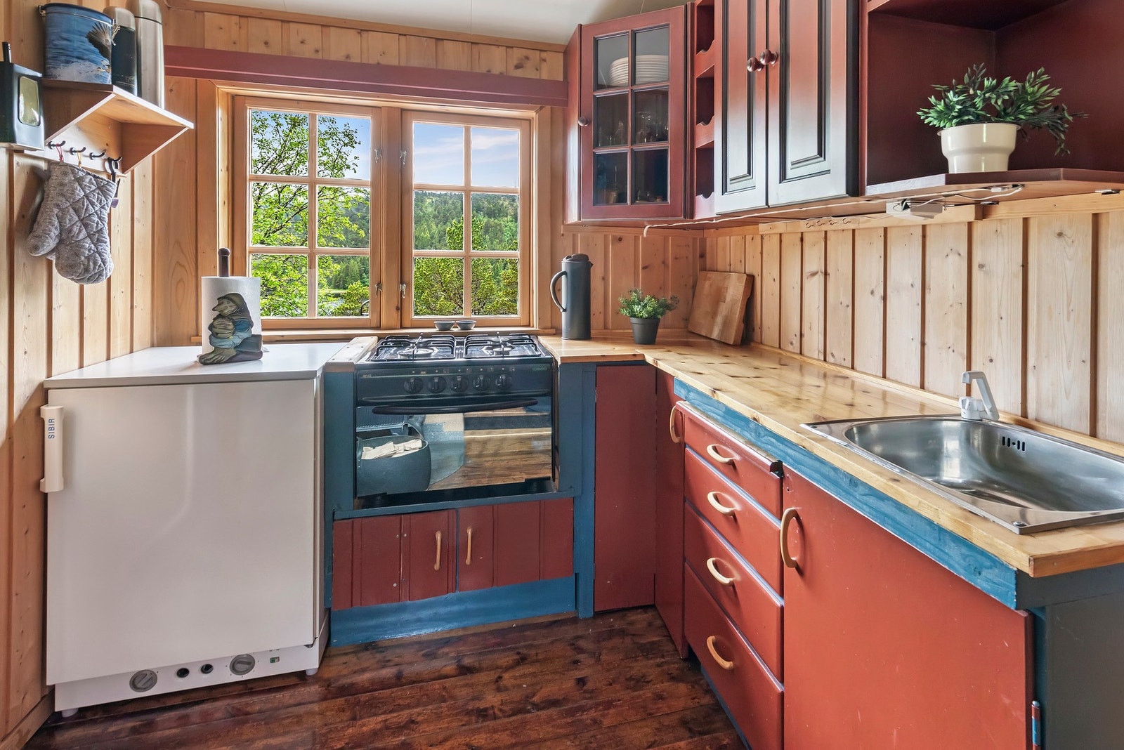 Kjøkkeninnredning med glatte og profilerte fronter og benkeplate i heltre Galleribilde