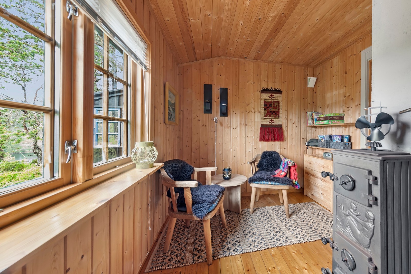 Lys og koselig stue med store vindu som slipper inn rikelig med naturlig lys og gir en flott utsikt Galleribilde