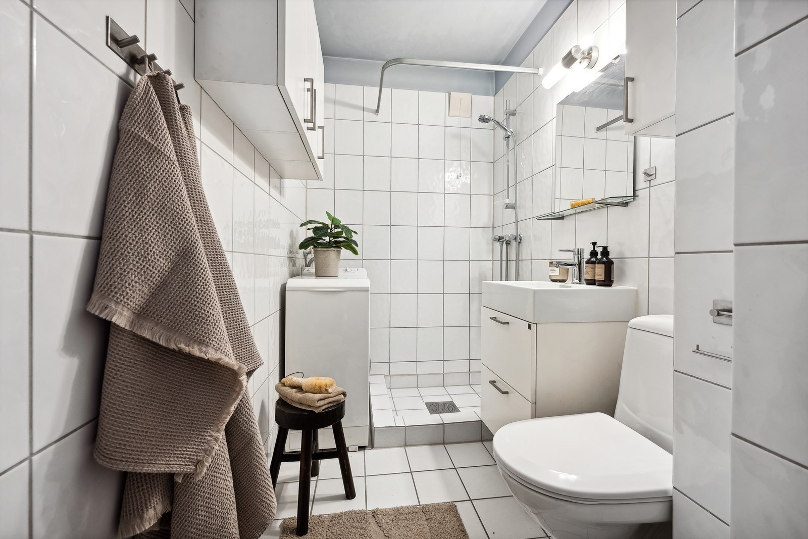 Lyst, flislagt baderom med underliggende elektriske varmekabler - innredning, servant og batteri ble skiftet i 2016, og klosett ble skiftet i 2022 Galleribilde