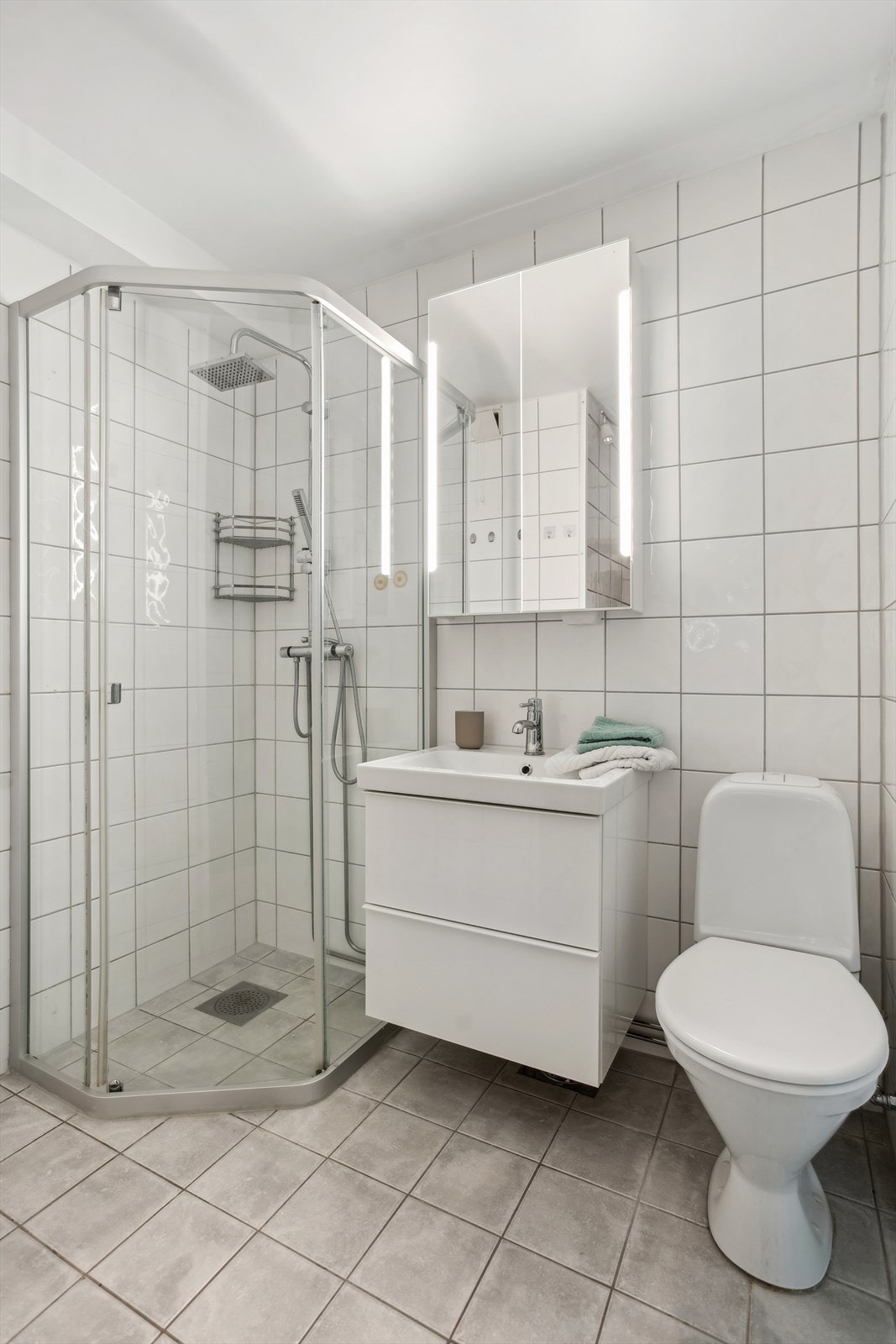Badetrommet ble oppgradert i 2007 i regi av borettslaget.
Badet er innredet med servantskap med ett-greps blandebatteri, speilskap med lys, gulvstående toalett, avskjermet dusjhjørne med glass, blandebatteri og dusjgarnityr. Galleribilde
