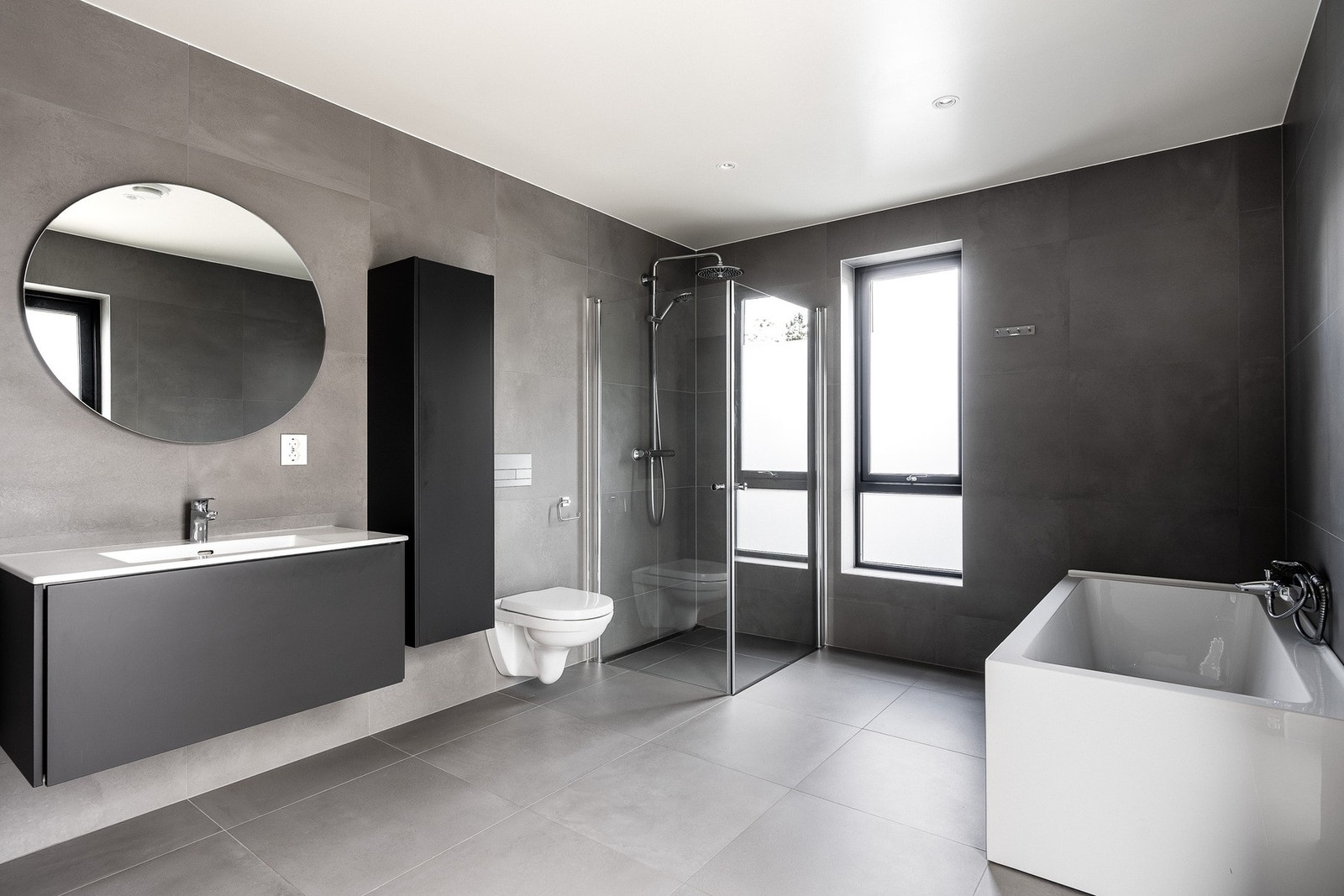 Romslig bad med dusj, badekar, toalett og servant med underskap. Galleribilde