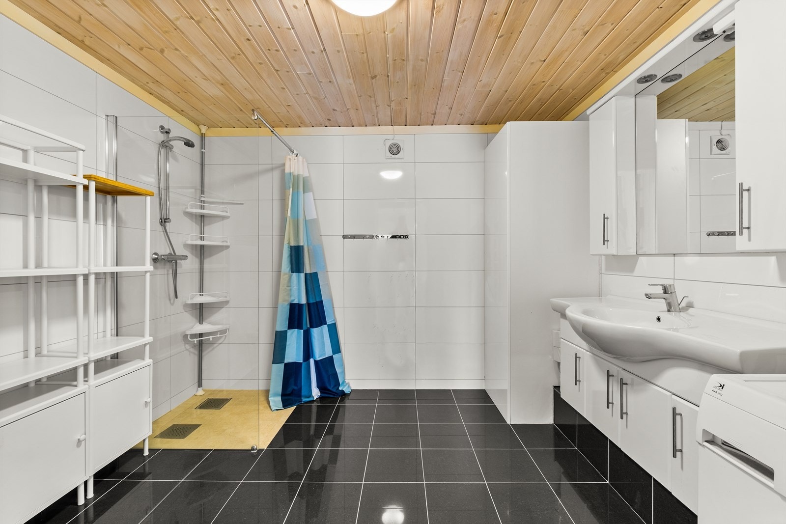 Pent flislagt bad med opplegg for vaskemaskin. Galleribilde