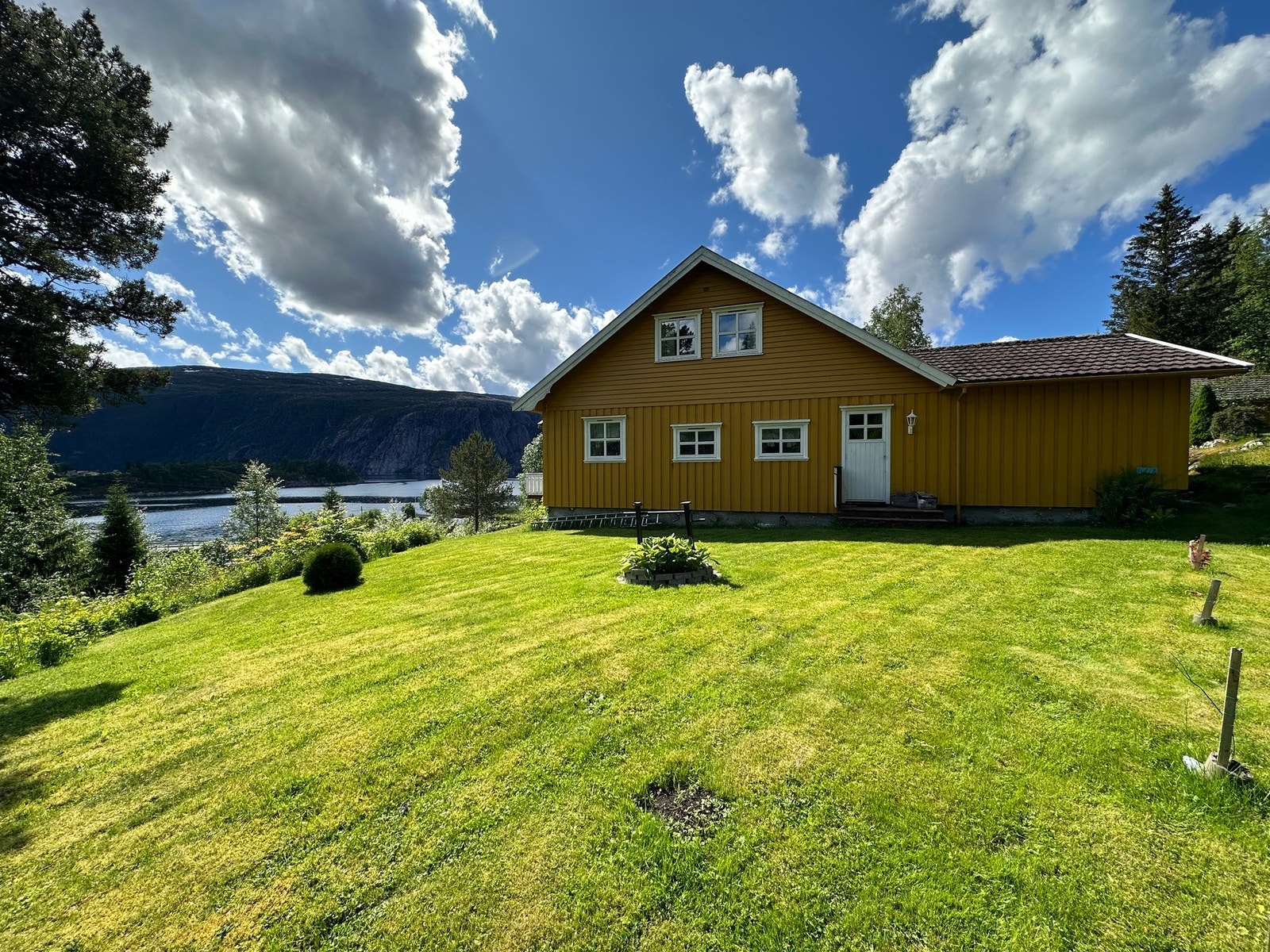 Romslig tomt med plenarealer og diverse beplantning Galleribilde