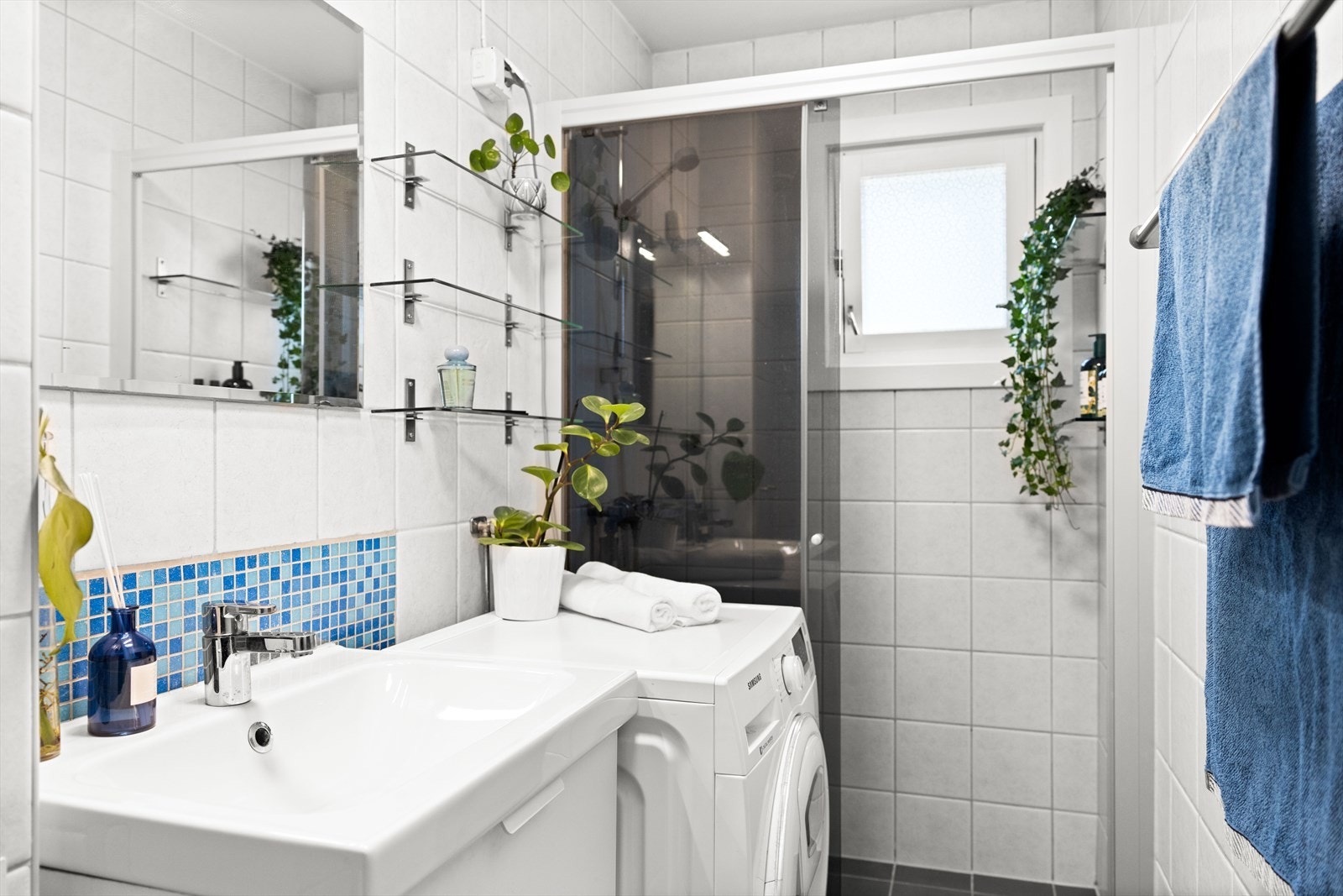 Badet er innredet med klosett, servant med innredning, speil med lys og dusjhjørne med skyvbar glassdør. Galleribilde
