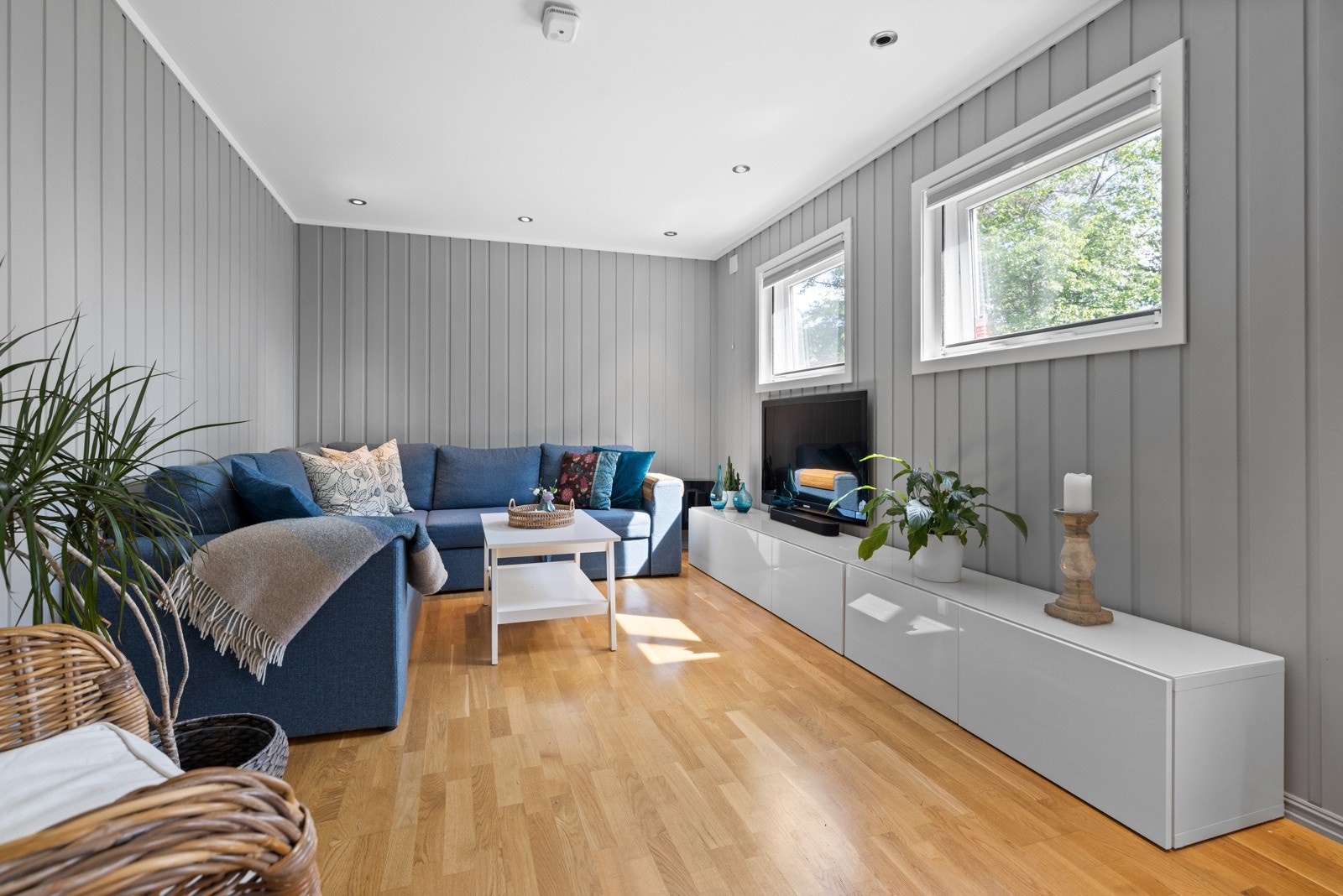 Kjellerstuen har malt panel på veggene, downlights i himlingen og gyllen parkett på gulv med gulvvarme Galleribilde