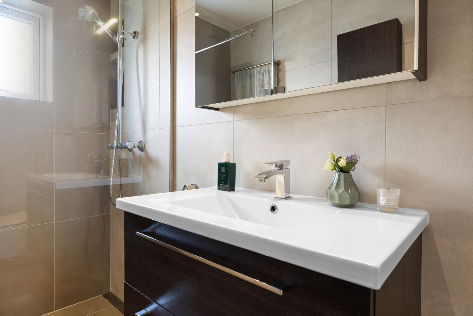 Her er det downlights i himlingen, store, grå fliser på veggene og matchende fliser på gulv med gulvvarme Galleribilde