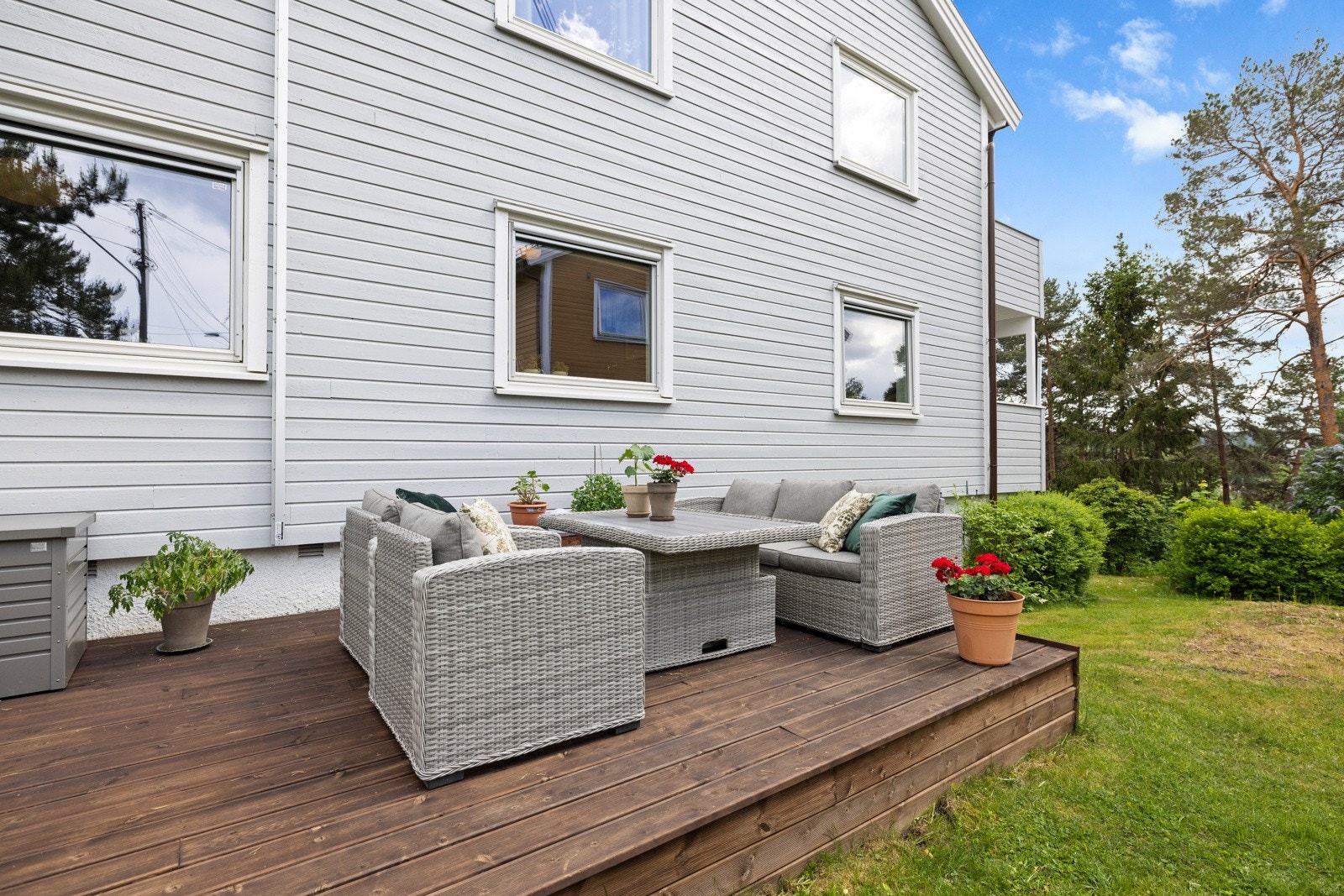 Markterrassen har beiset tredekke, og langs ene enden er det en plassbygd blomsterkasse Galleribilde